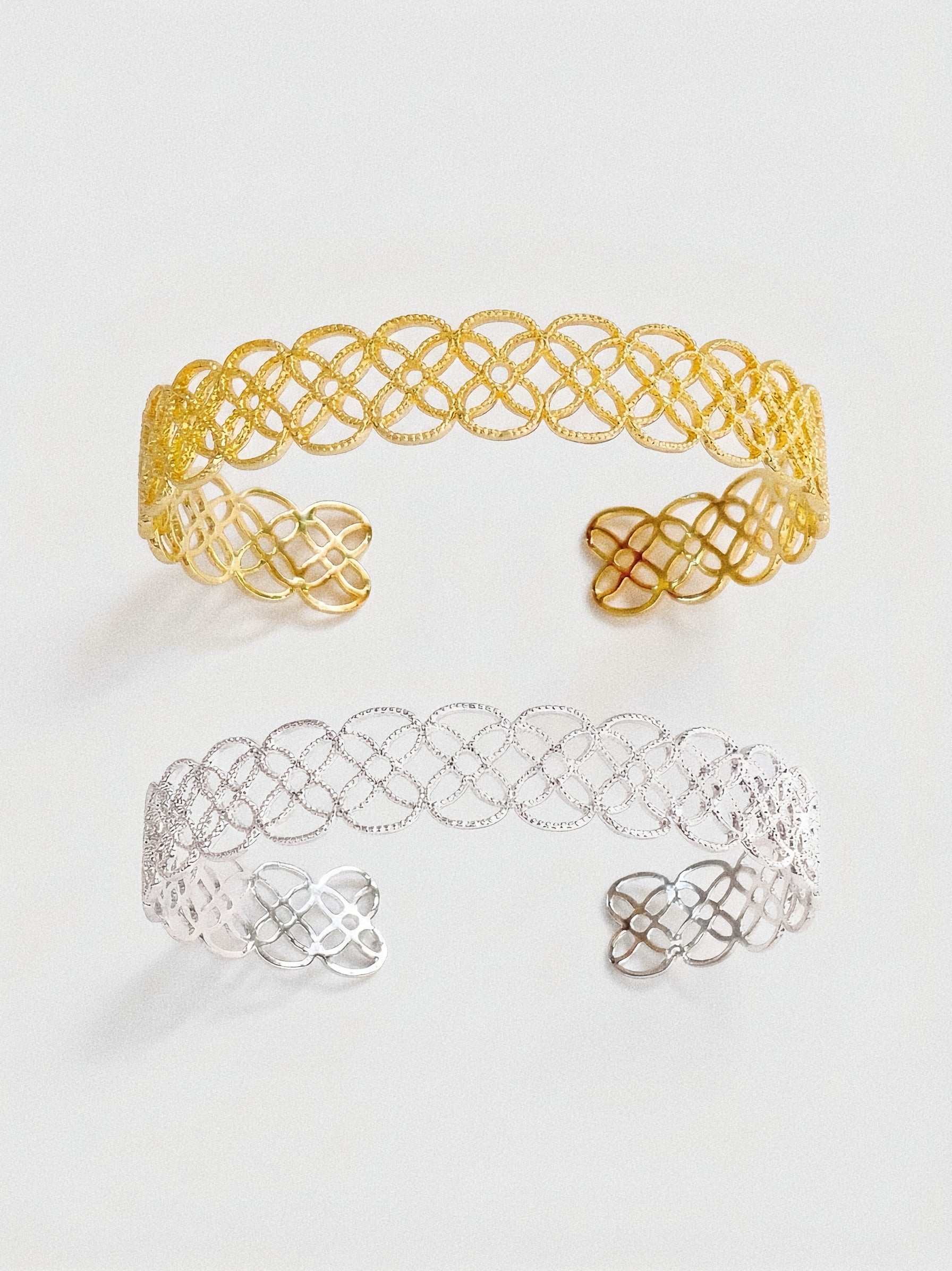 A comparison view of the Arabesque Petal Lace Cuff in both vintage gold and sterling silver plating.
