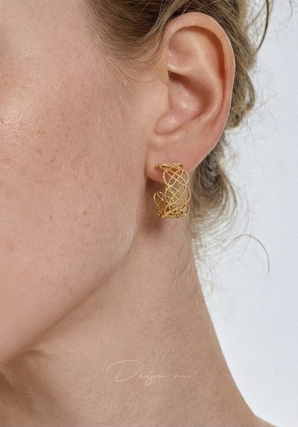 Lifestyle shot of a woman wearing the gold lace hoops, demonstrating their face-framing effect.