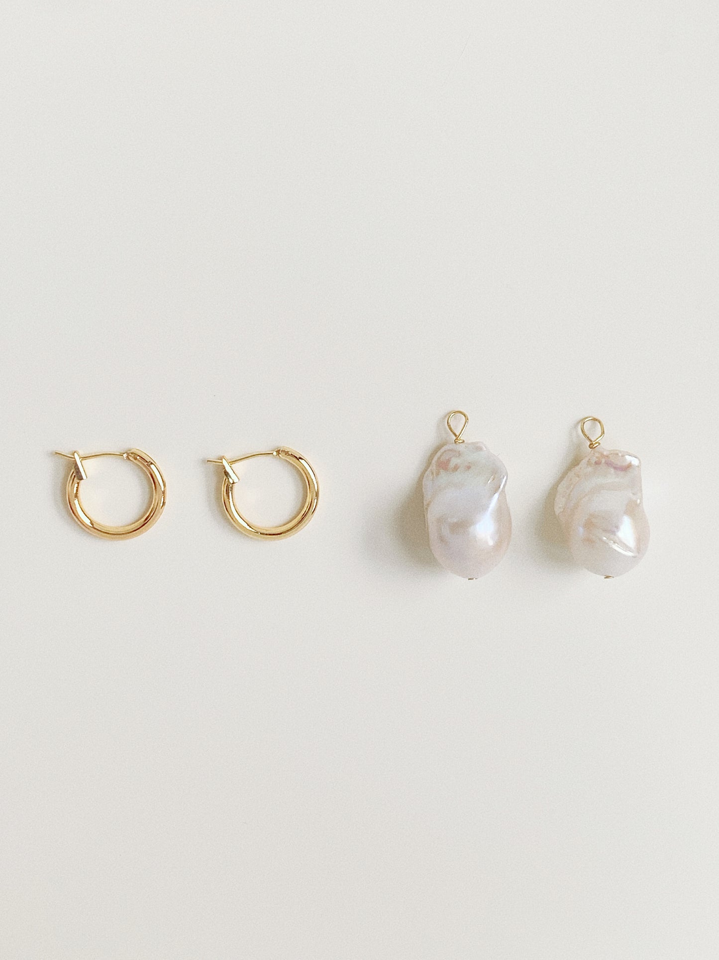 Creative layout showing the pearl charms separated from the gold hoops, demonstrating the 2-way detachable feature.