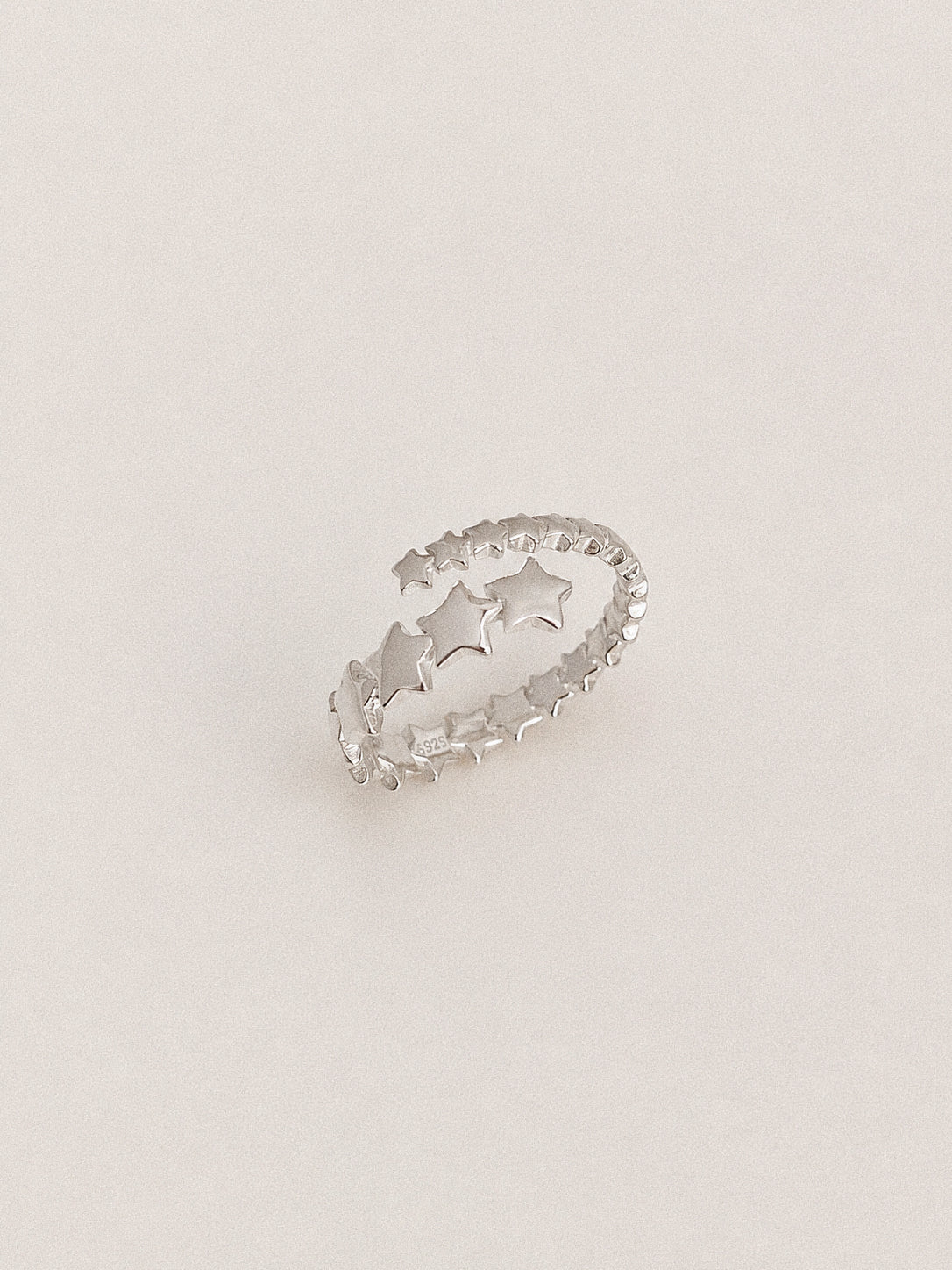 Angled view of the Drift multi star ring showing its double row band, changing star sizes and S925 hallmark.