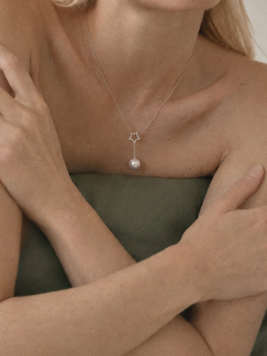 Astra sterling silver Edison pearl Y necklace worn below the collarbone, showing its star and 3 cm pearl drop.