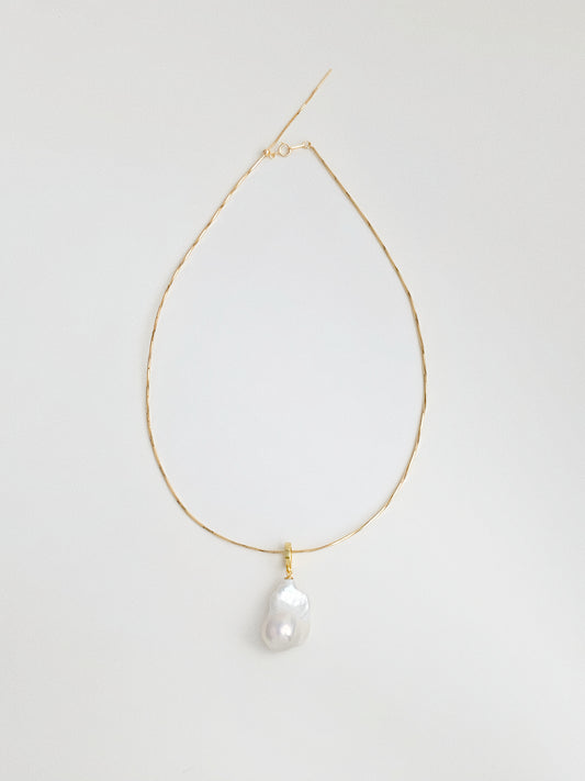 Full flat lay of snake chain choker necklace with natural baroque fishtail freshwater pearl pendant