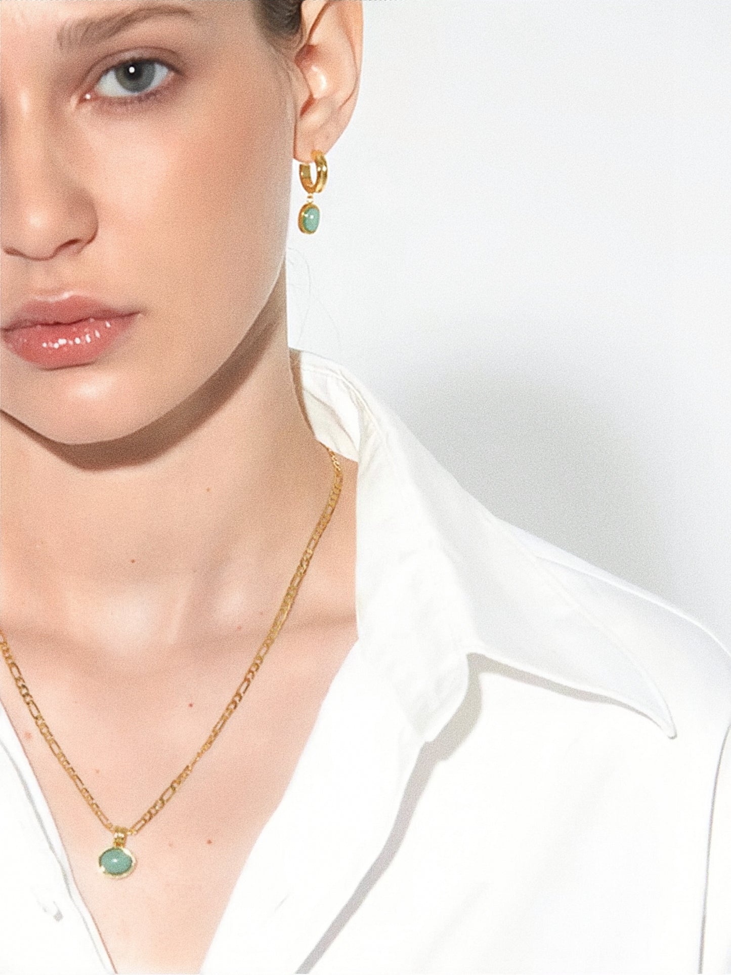 Lifestyle shot of a model wearing the aventurine necklace and hoop earrings, showcasing the set's elegant fit.