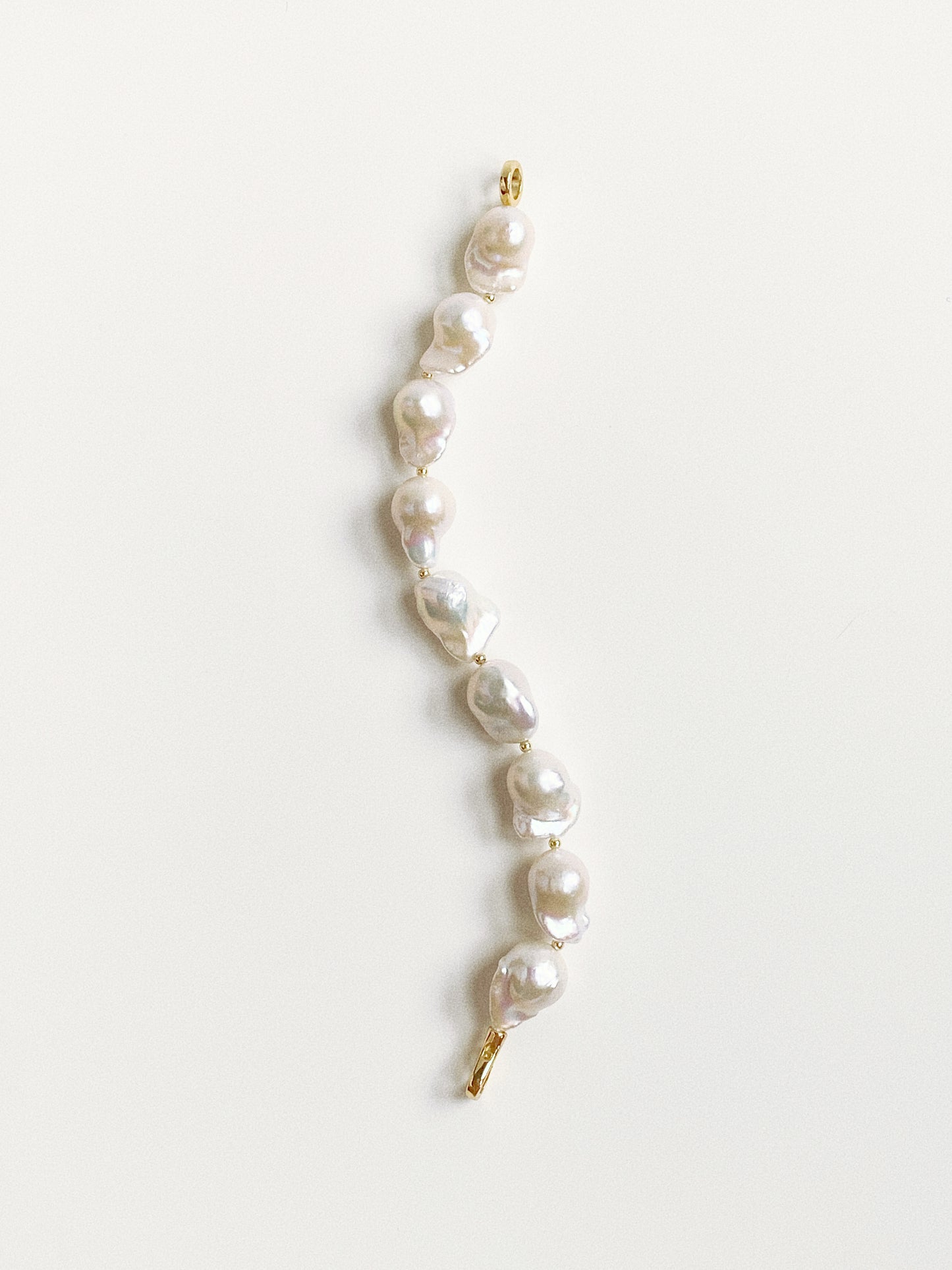 Vertical view of the pearl bracelet showing the unique fish-tail shapes and variations of the 11-13mm pearls.