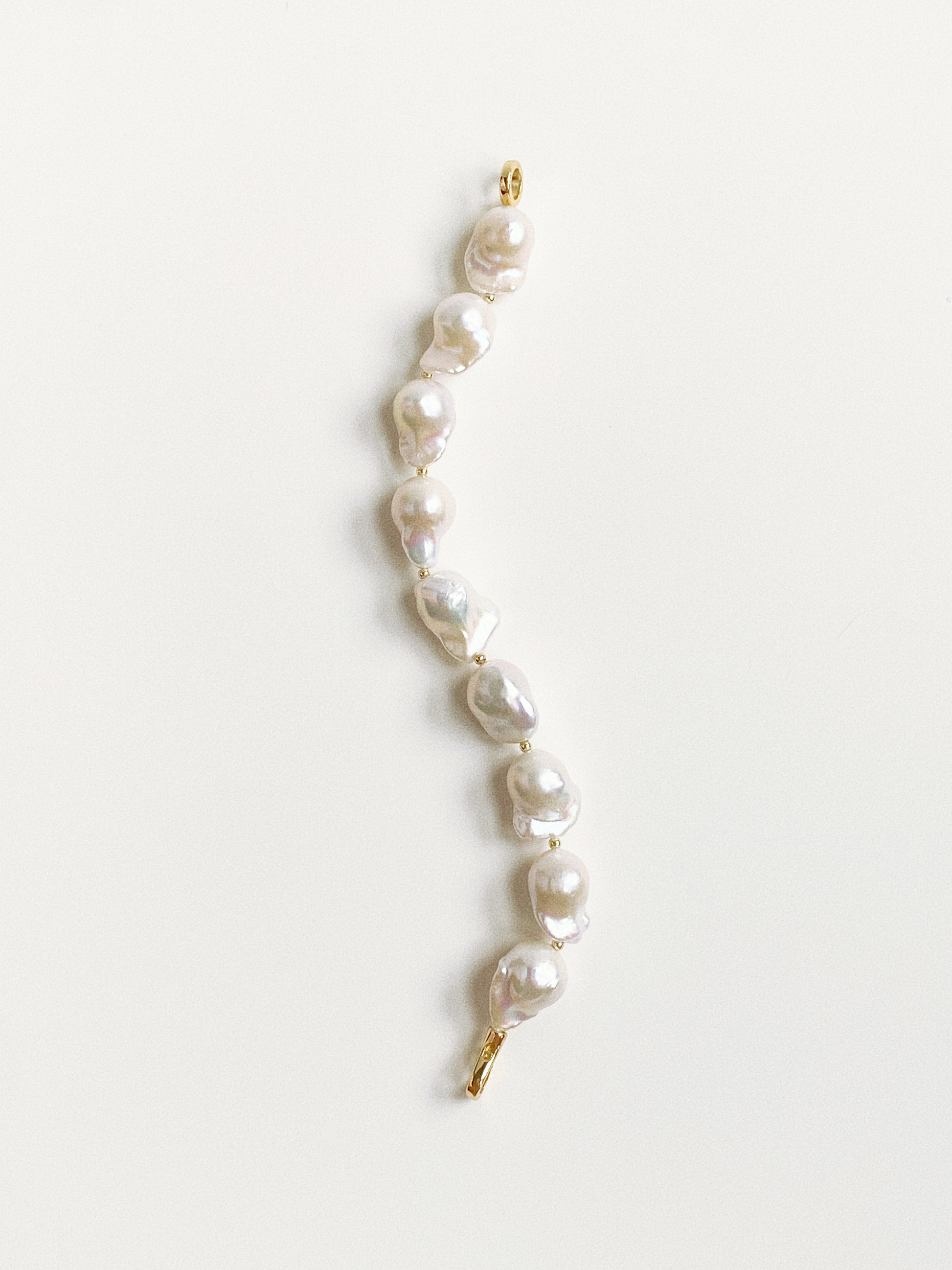 Vertical view of the pearl bracelet showing the unique fish-tail shapes and variations of the 11-13mm pearls.
