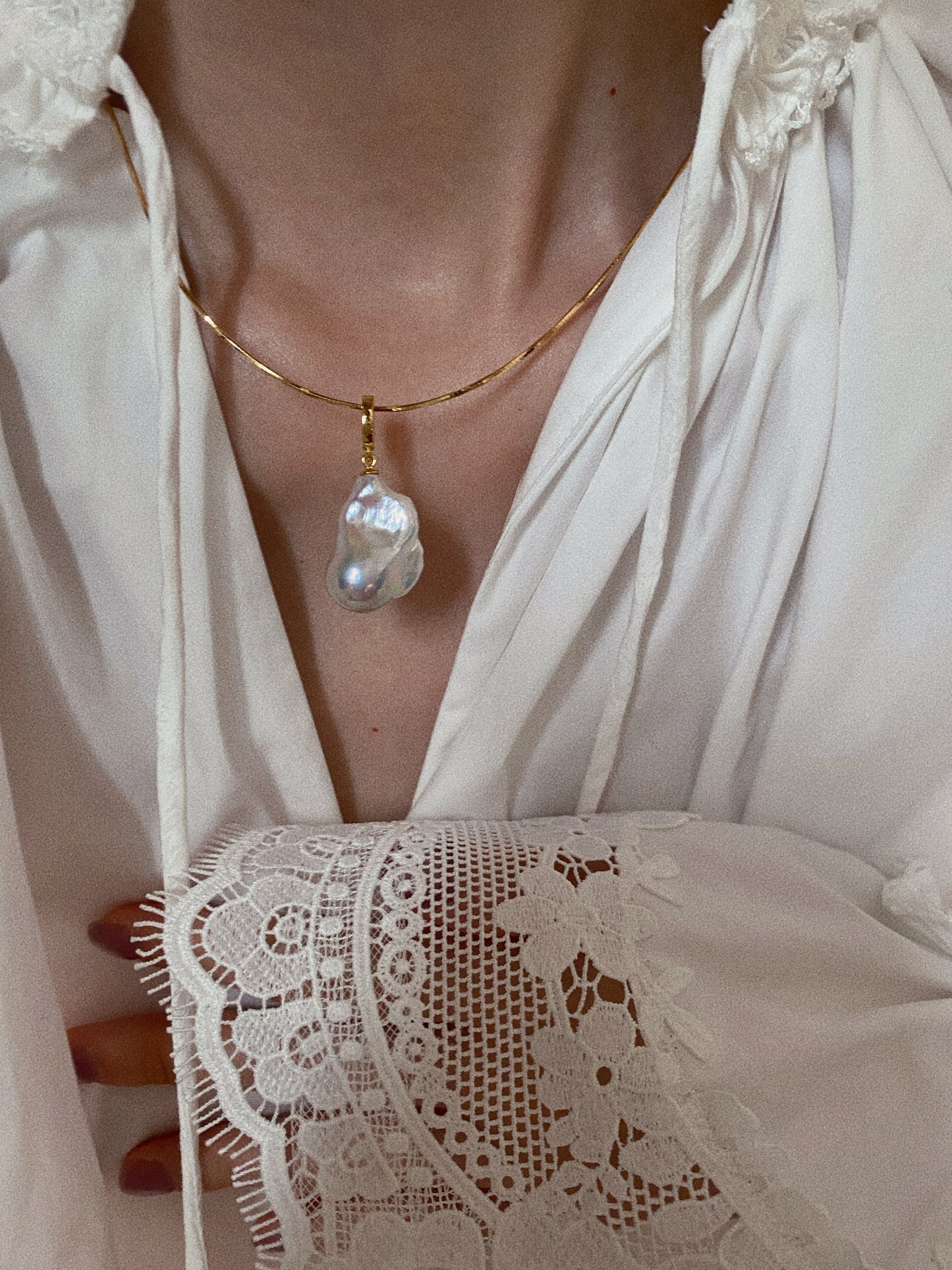 Gold snake bone chain choker with baroque fishtail pearl pendant styled with vintage lace blouse