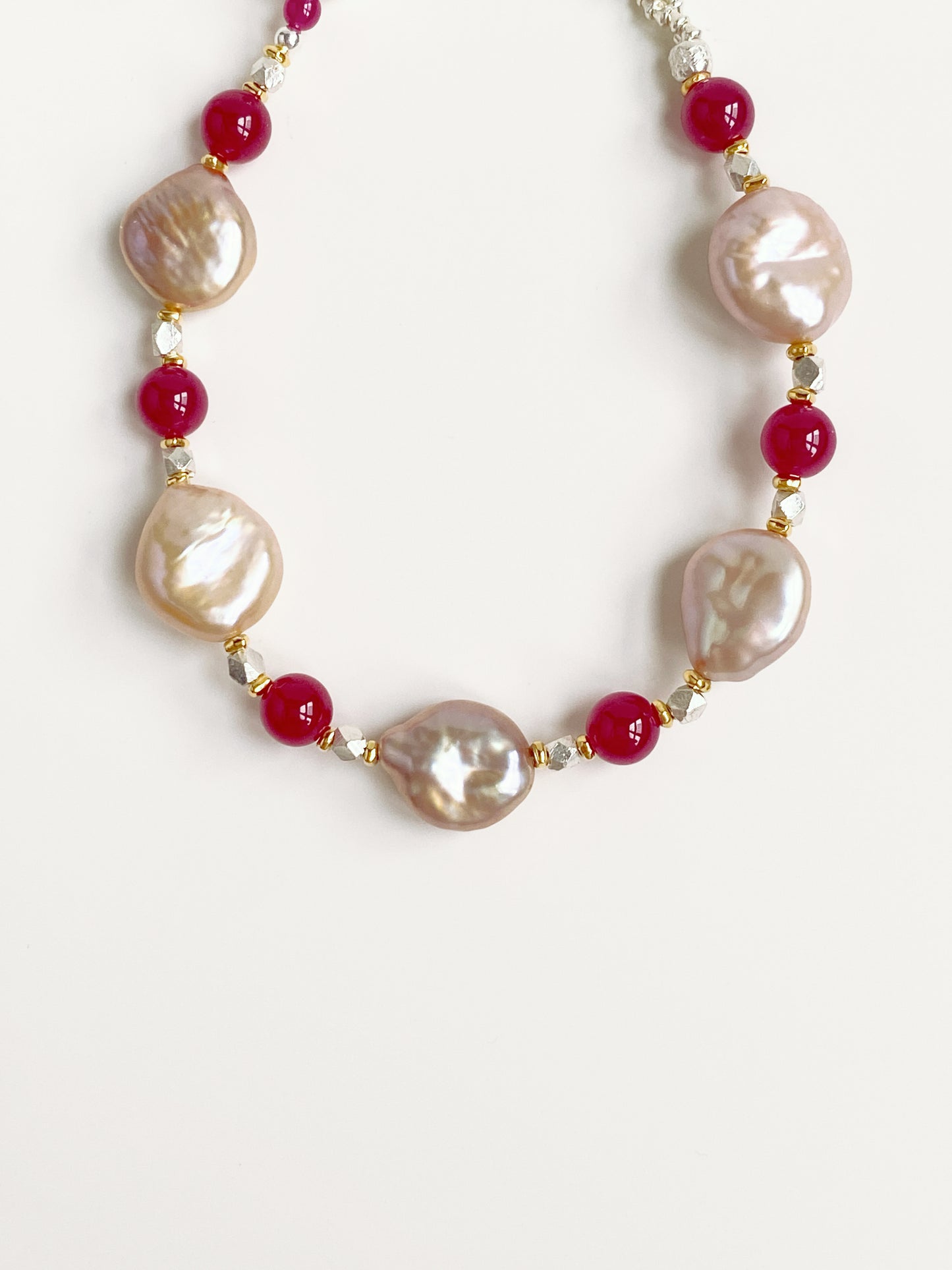Close-up detail of 1.4cm flat baroque pearls and 6mm red corundum beads highlighting natural gemstone textures.