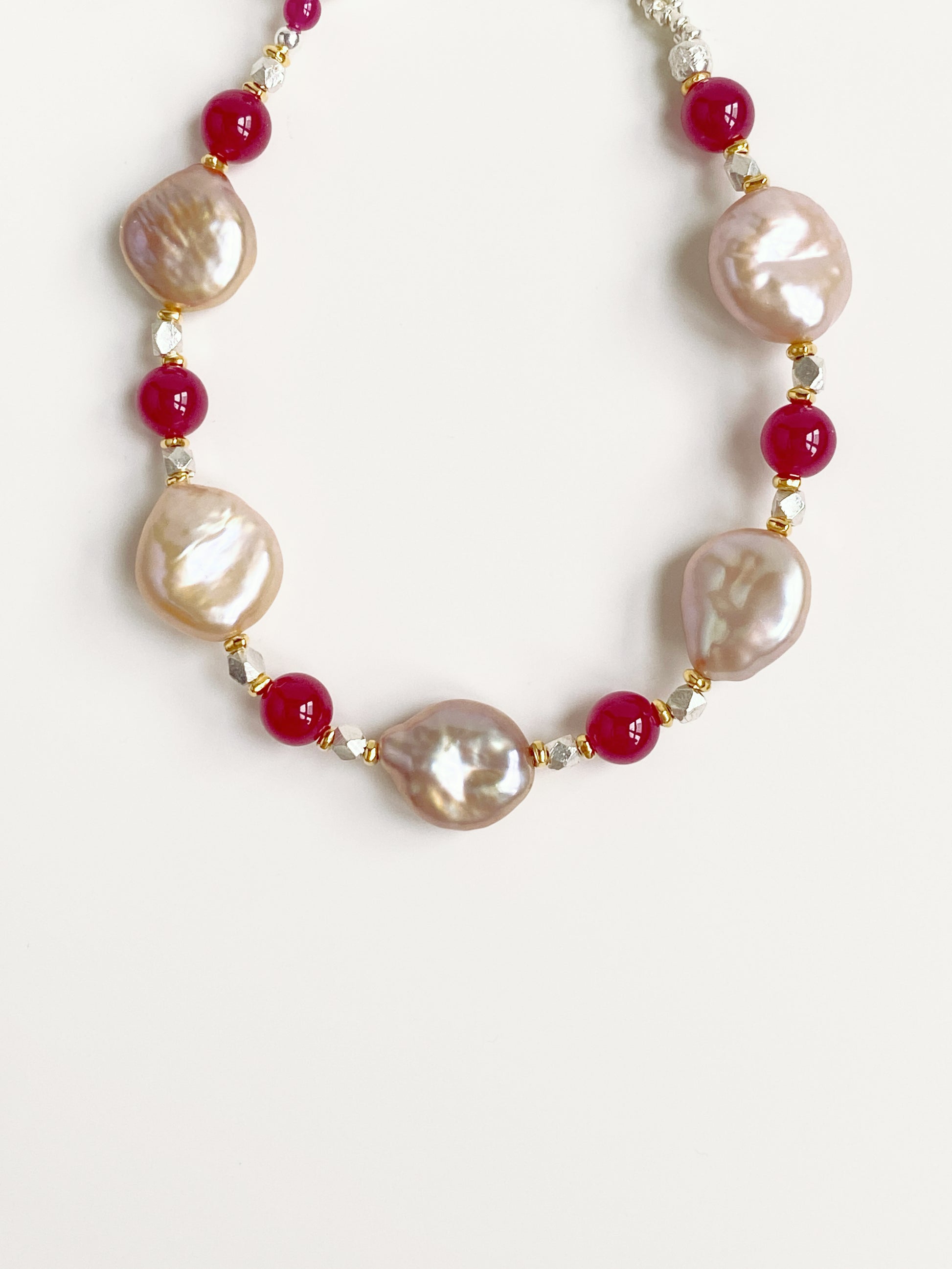 Close-up detail of 1.4cm flat baroque pearls and 6mm red corundum beads highlighting natural gemstone textures.