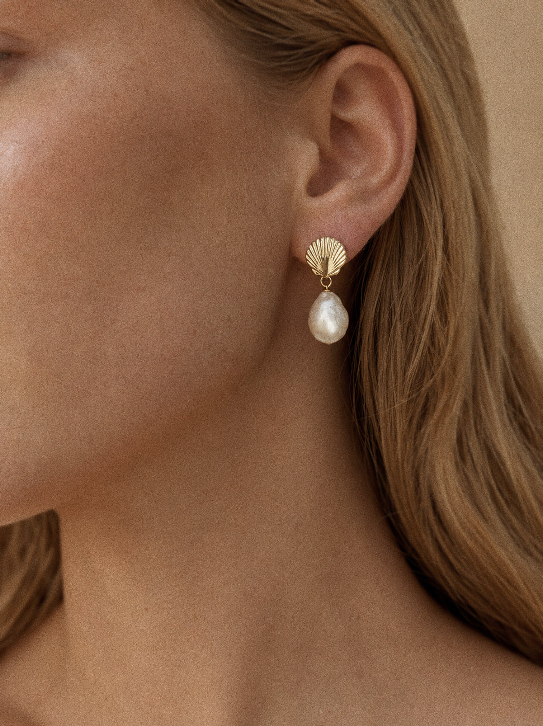Close view of the Shore freshwater baroque pearl drop earrings showing the sculpted shell stud and irregular pearl shape.