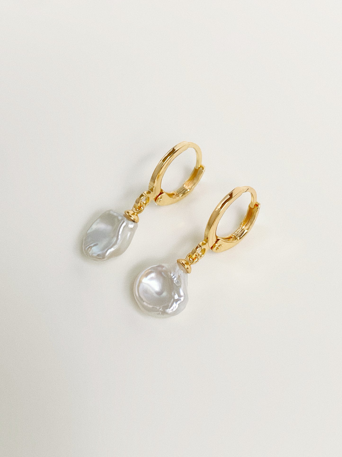 Close-up of natural freshwater petal pearl huggie hoop earrings showing organic pearl shape and lustre