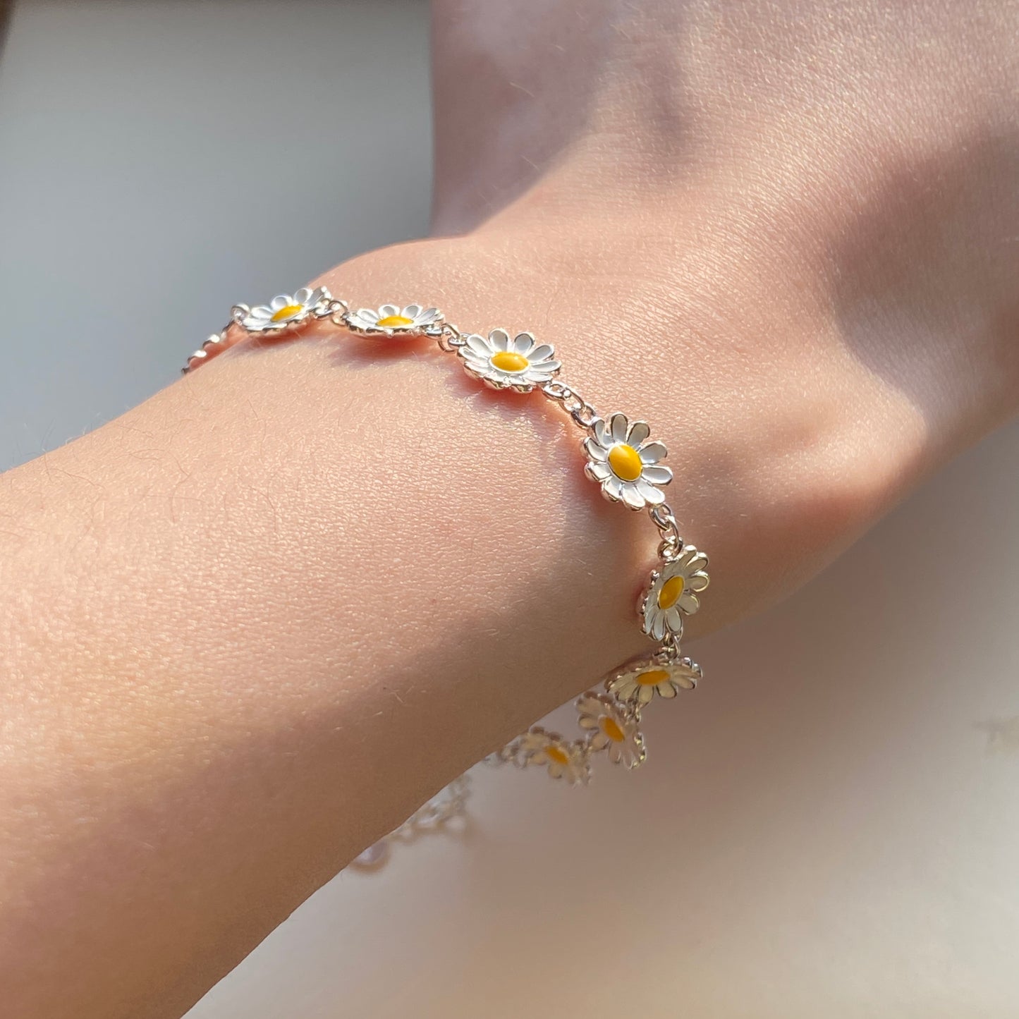 Row of small enamel daisies linked on fine sterling-silver chain