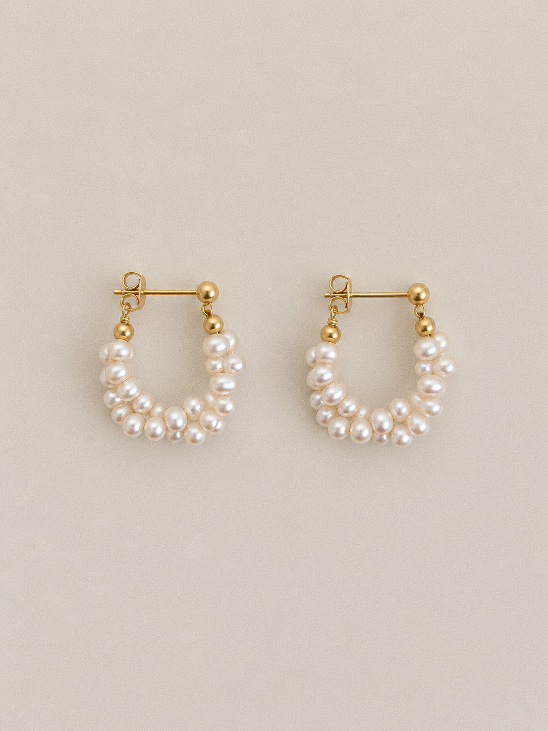 Pair of Garland freshwater pearl hoop earrings with twisted pearl strands, gold-tone ball studs and butterfly backs.