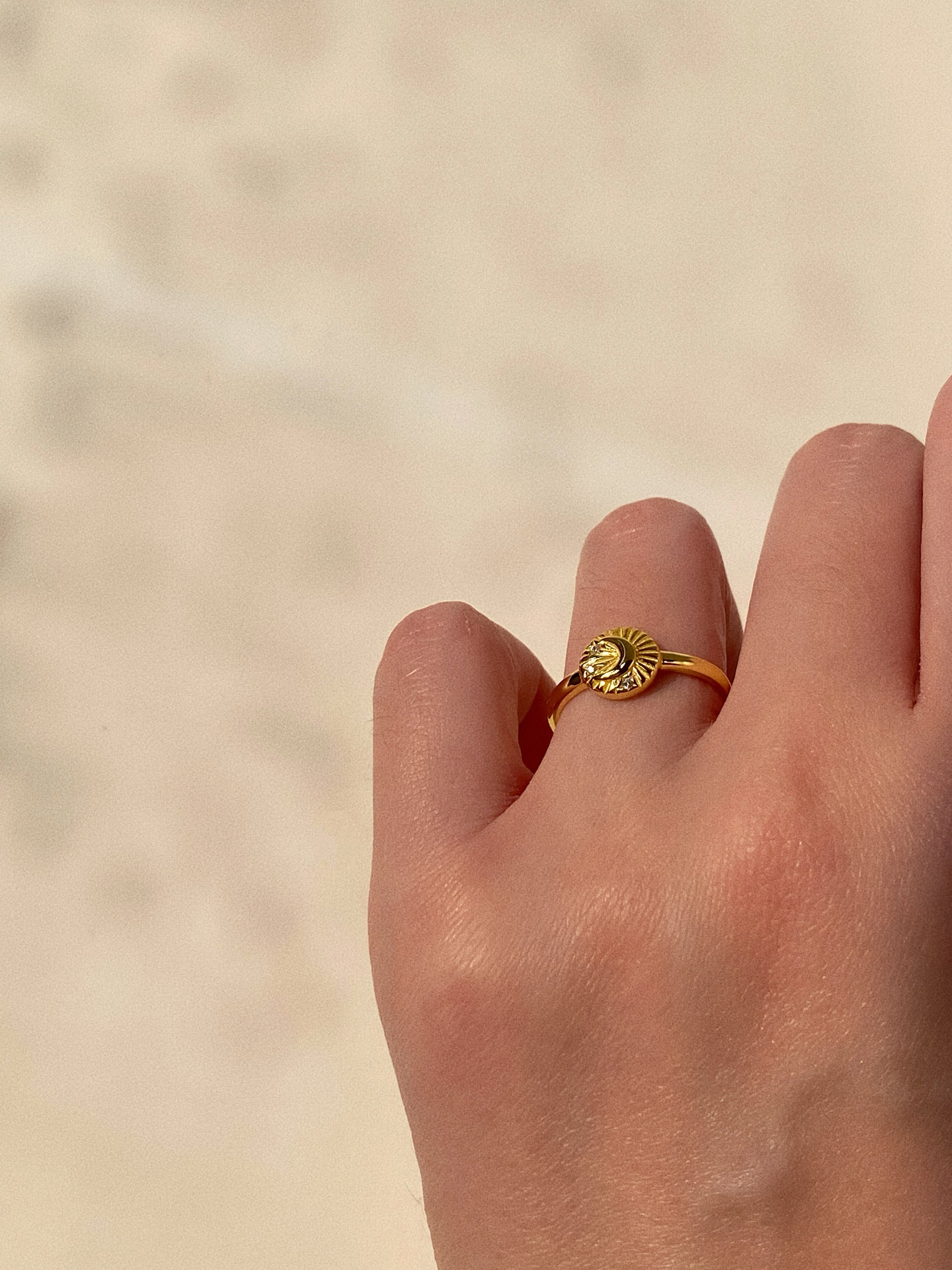 A woman wearing the gold celestial moon and star signet ring on her finger, showing its 8mm face width.