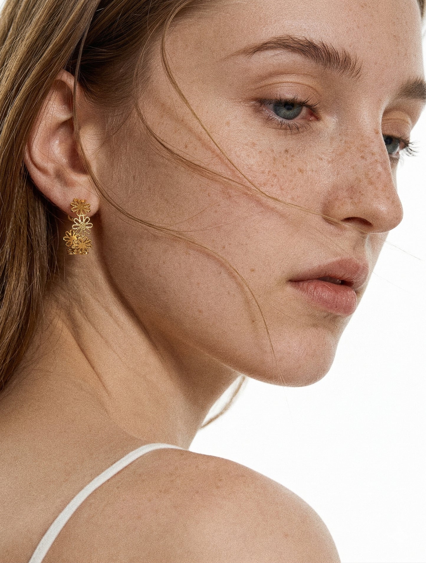 Gold daisy lace floral open hoop earring worn on model in side profile showing 19mm hoop and delicate floral detail by Deja Vu Jewellery