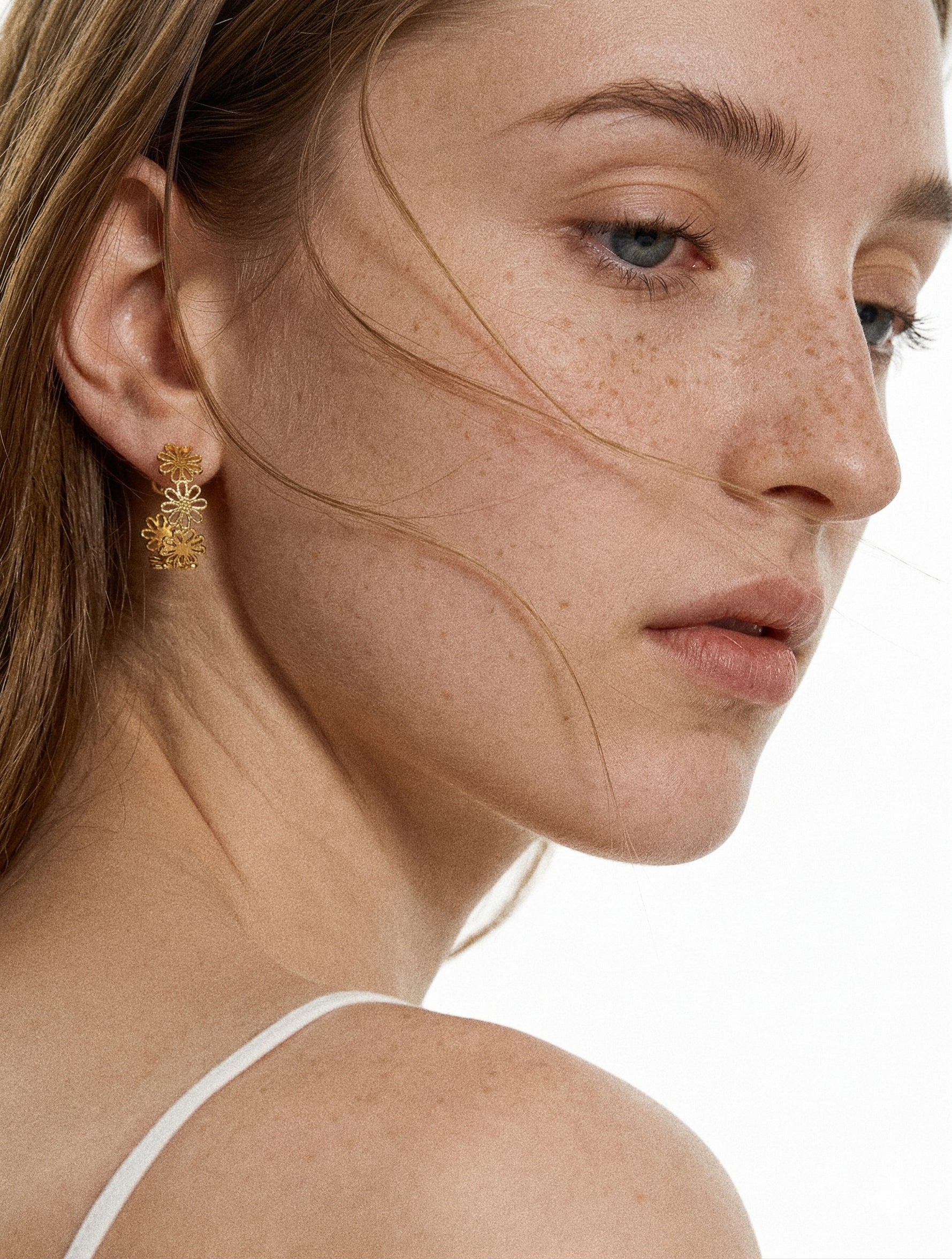 Gold daisy lace floral open hoop earring worn on model in side profile showing 19mm hoop and delicate floral detail by Deja Vu Jewellery