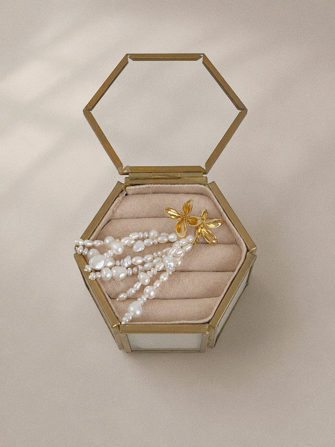 Fleur gold flower pearl earrings arranged inside a vintage-style jewellery box with blush velvet lining.