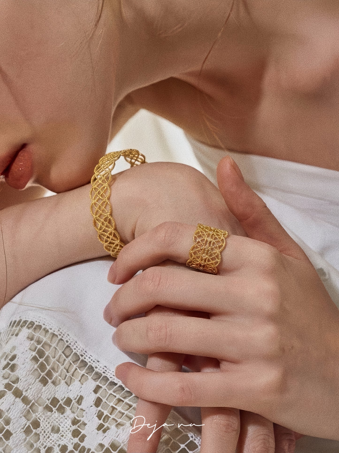 A lifestyle shot showing the Gossamer Bloom ring styled with a matching lace cuff bracelet in gold.
