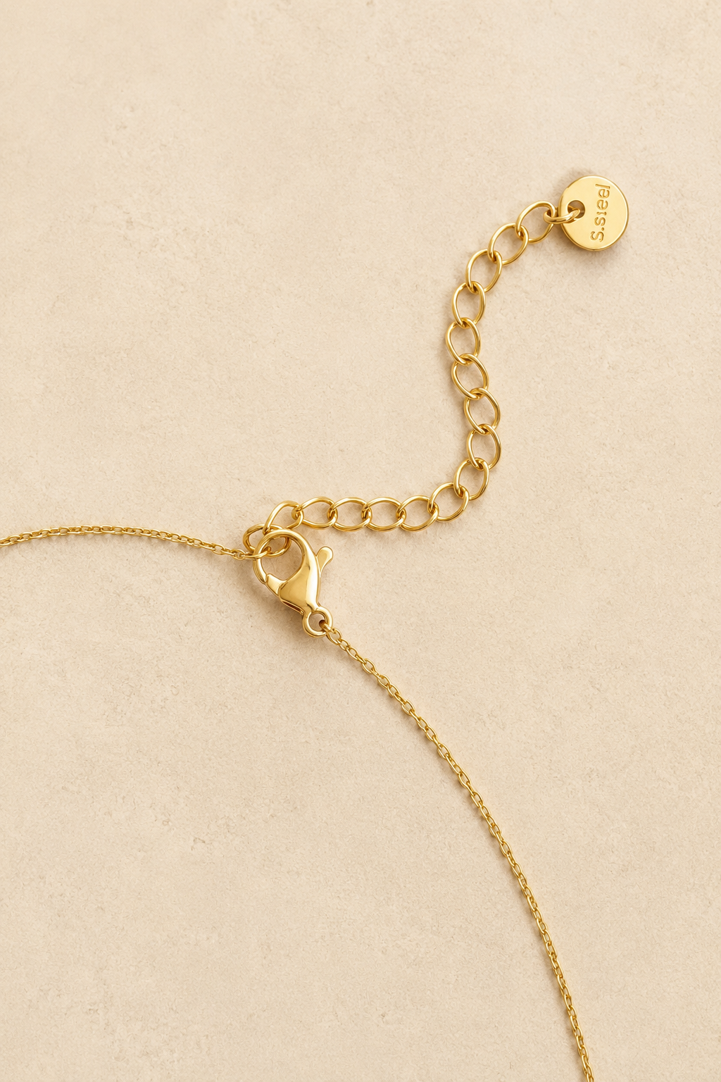 Lobster clasp and adjustable extender chain with a round stainless steel tag on a dainty waterproof gold necklace