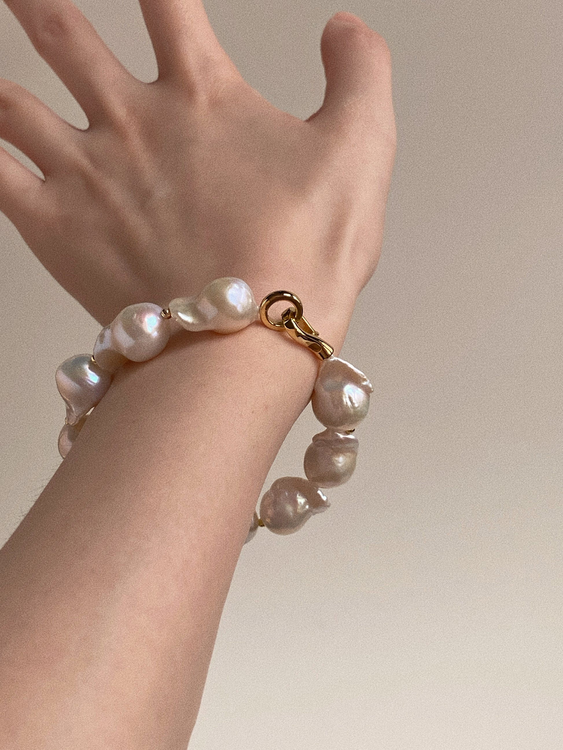 Model wearing the baroque pearl bracelet, highlighting the secure 14k gold plated S-hook clasp.