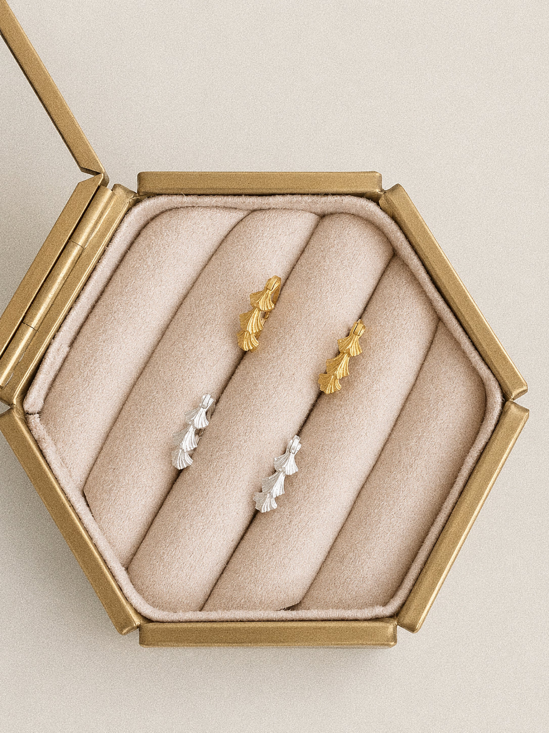 Gold and silver Grove botanical hoop earrings displayed together in a Deja vu Jewellery gift box.