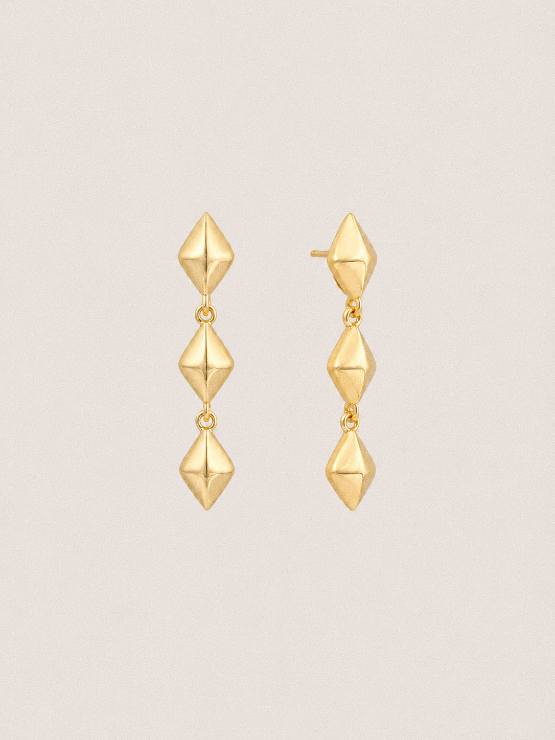 Gold plated star drop earrings, three faceted forms falling one below the next from a stud fitting.