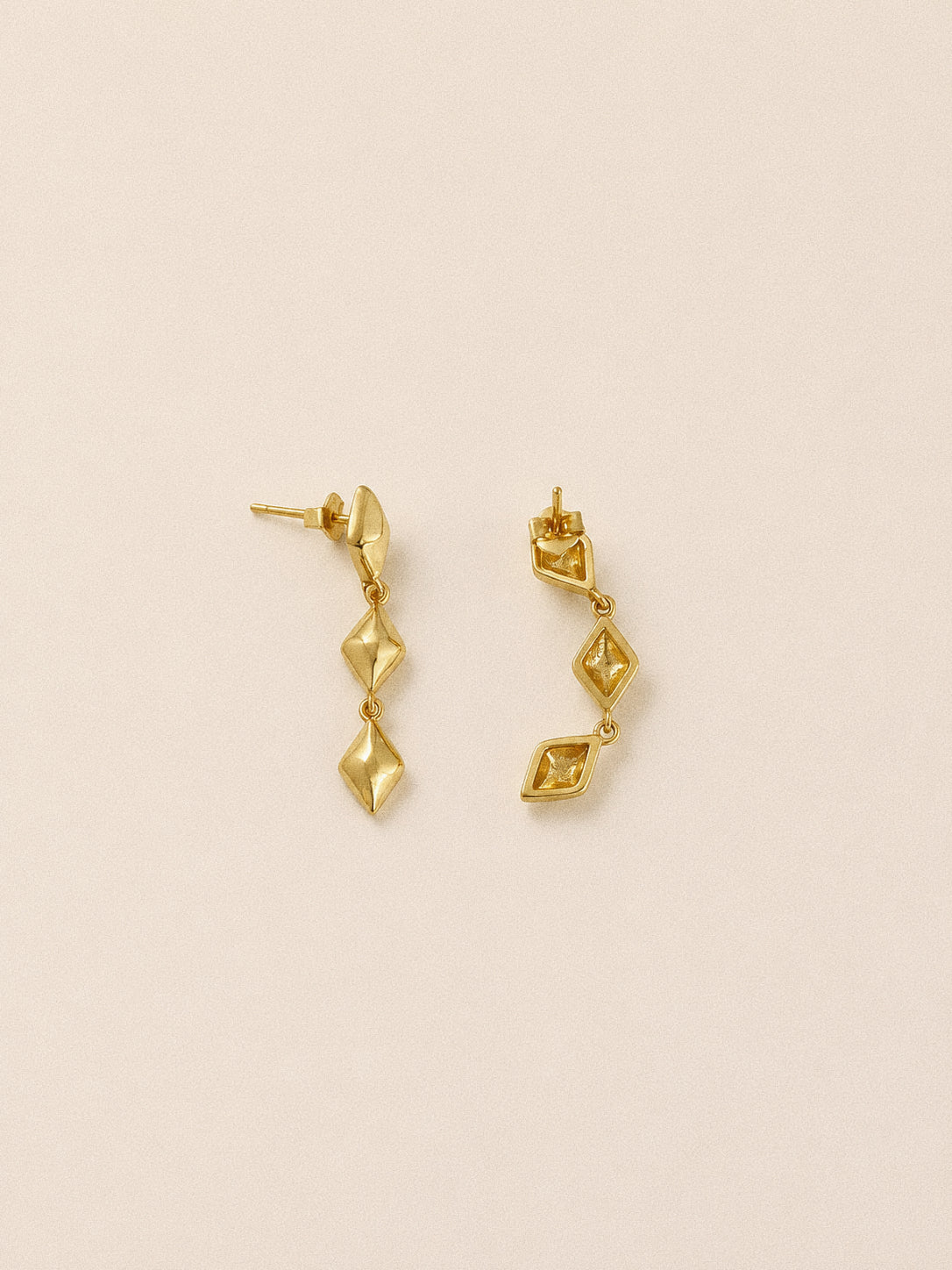 Side view of the gold star drop earrings showing their sterling silver posts and butterfly backs.