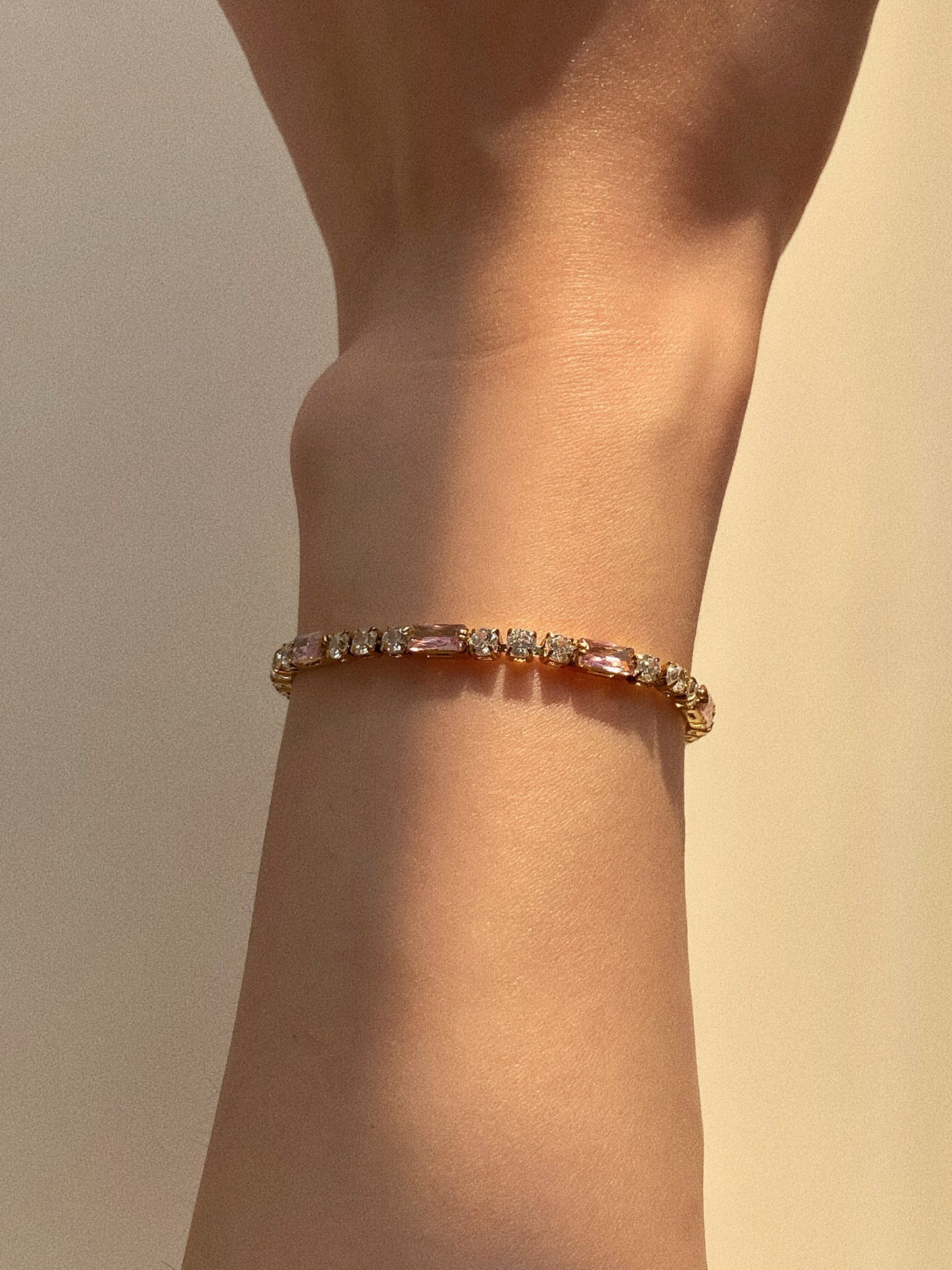 Detail of 18k gold plated baguette tennis bracelet showing secure clasp and sparkle under light.