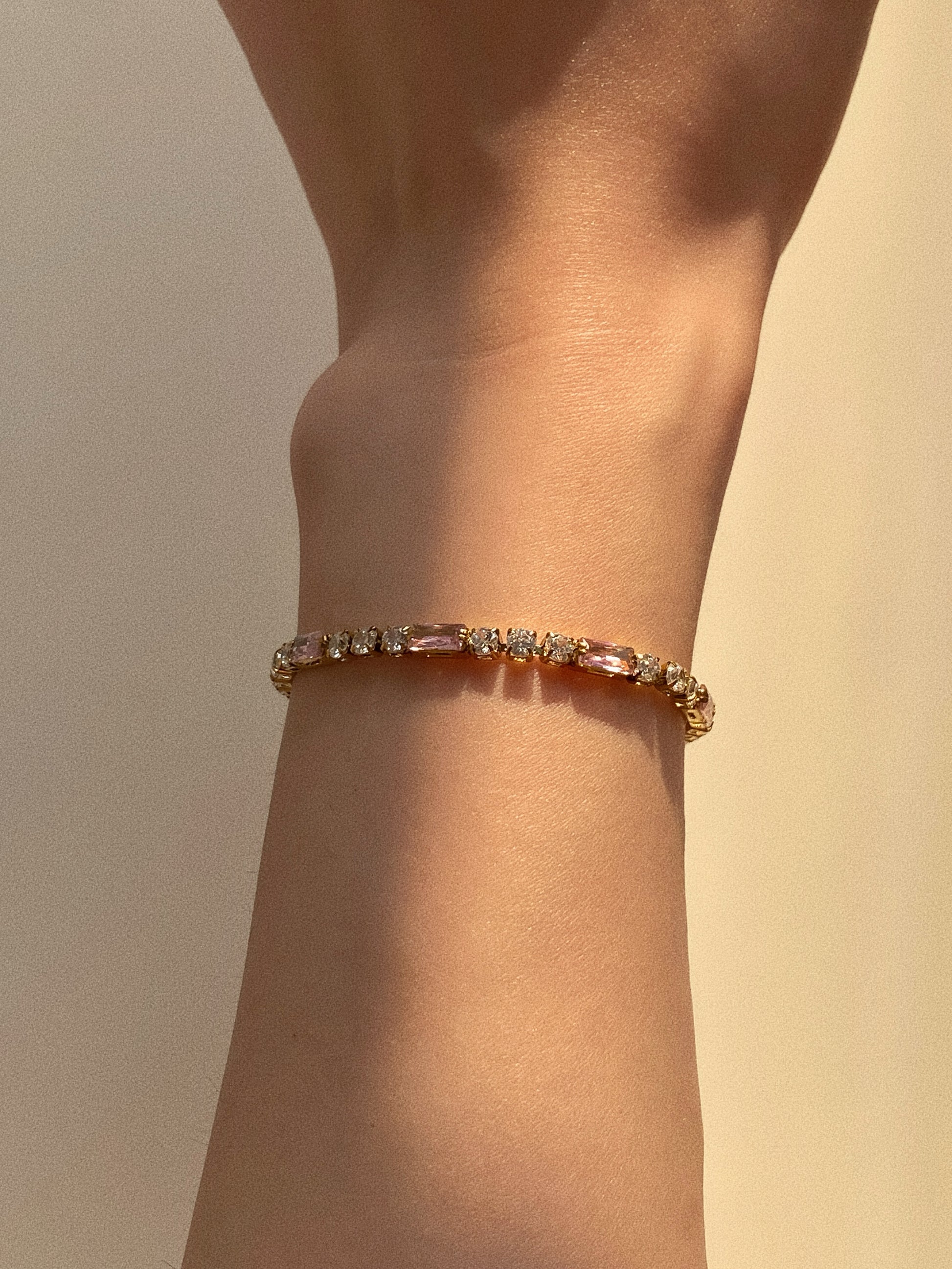 Detail of 18k gold plated baguette tennis bracelet showing secure clasp and sparkle under light.