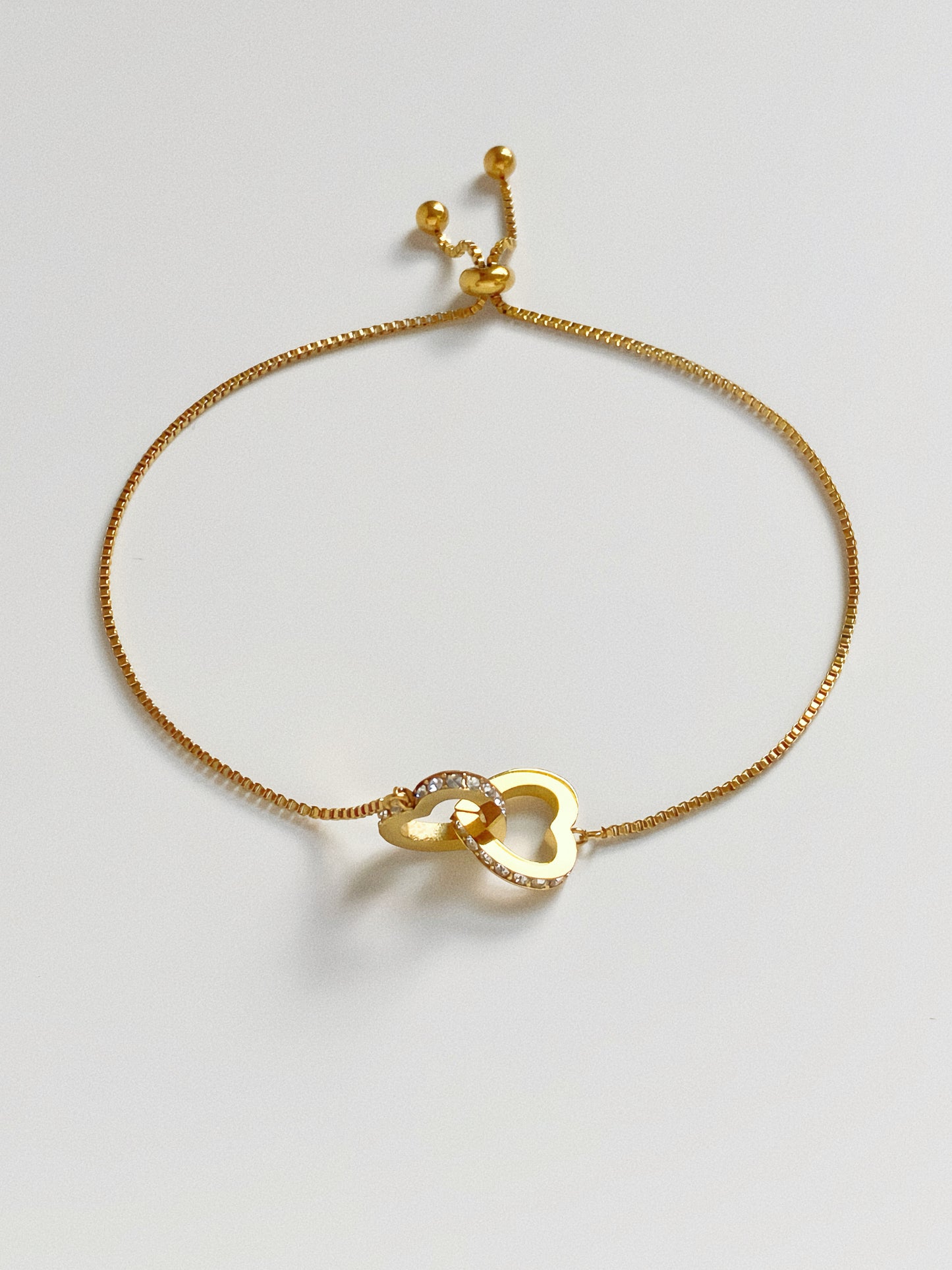 Detail shot of 18k gold plated stainless steel heart bracelet showing high-shine finish and crystal sparkle.