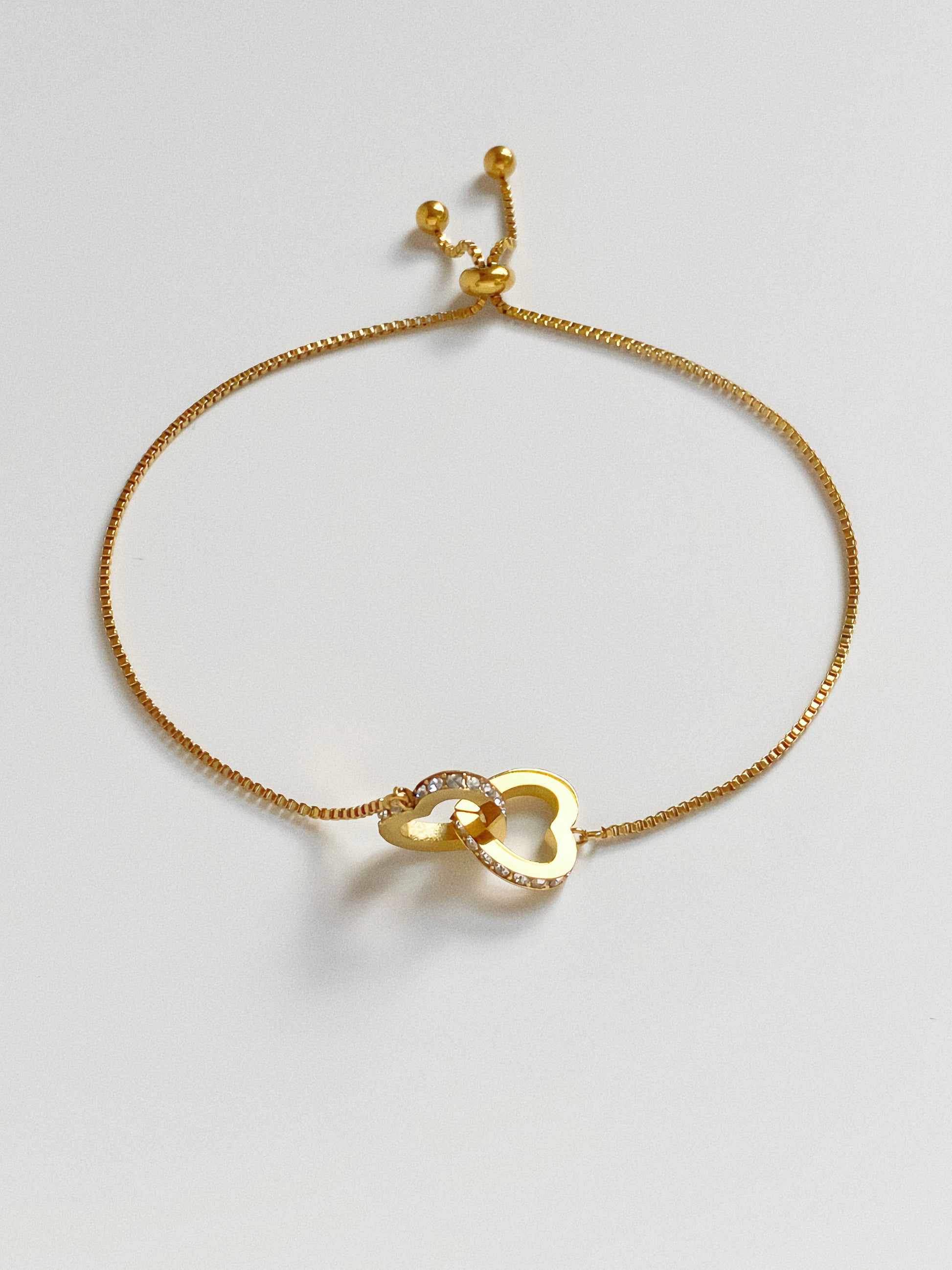 Detail shot of 18k gold plated stainless steel heart bracelet showing high-shine finish and crystal sparkle.