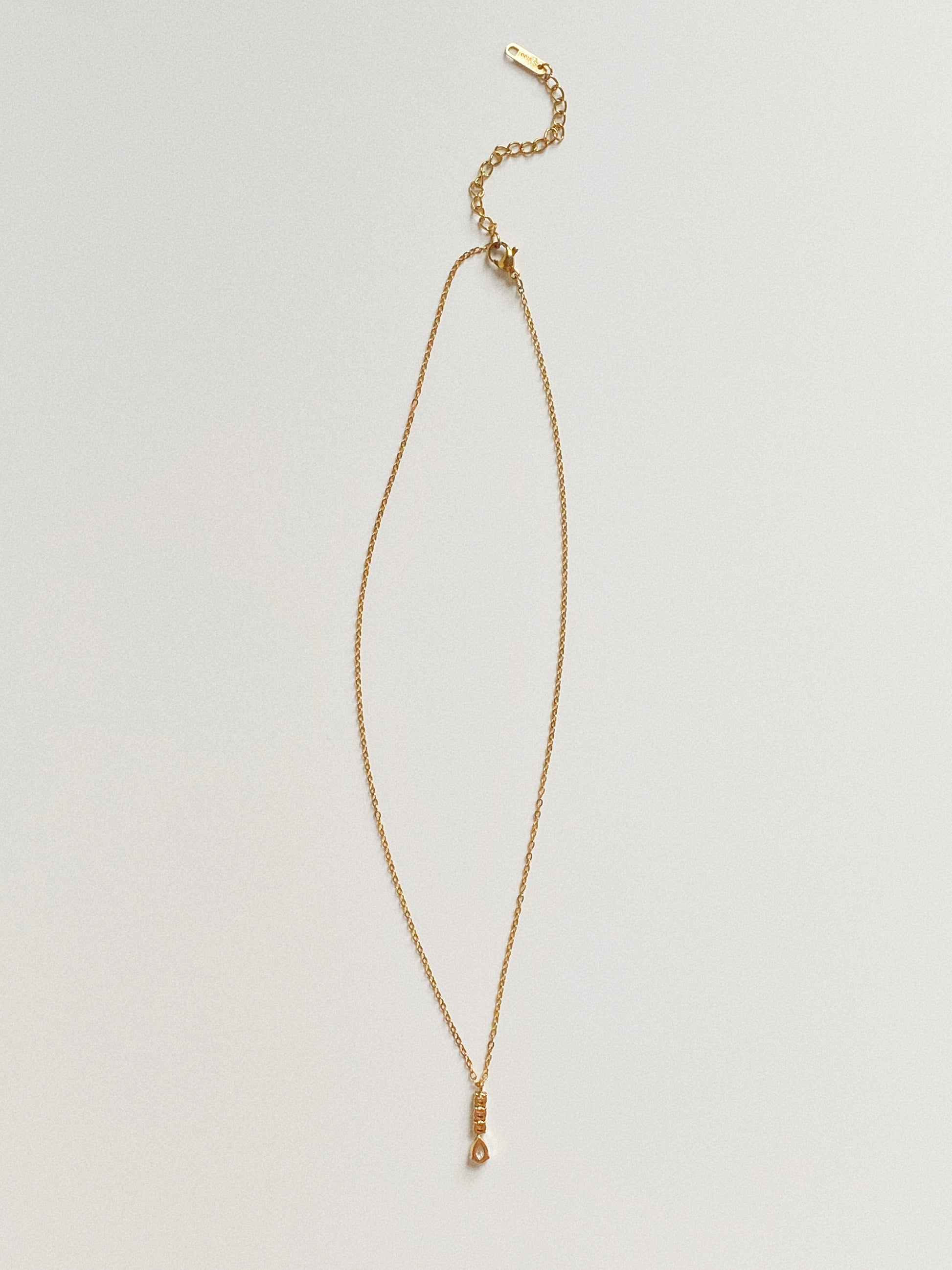 Back view of gold crystal pendant necklace showing adjustable extender chain and lobster clasp.