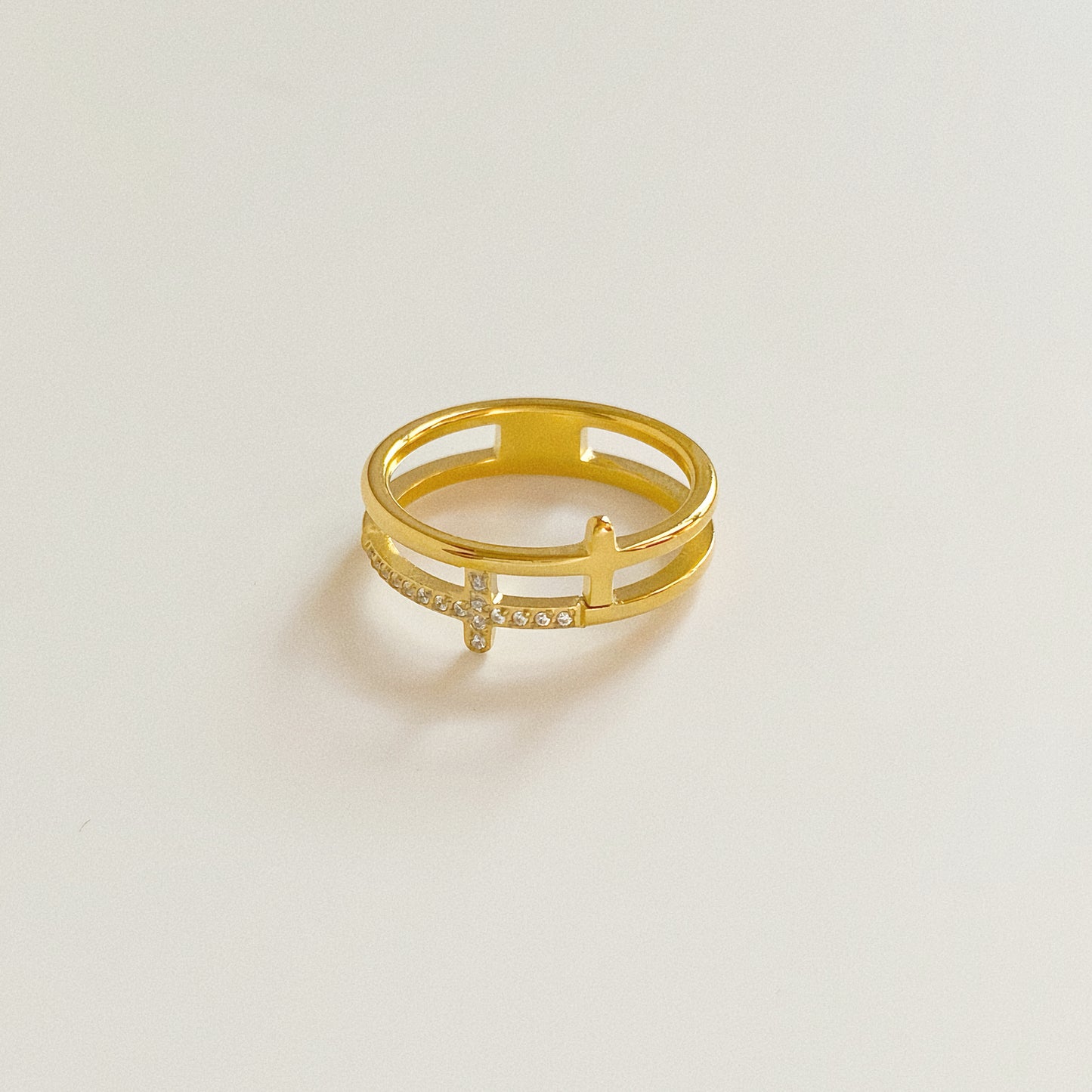 Waterproof gold cross ring isolated on white background, showing split shank design.