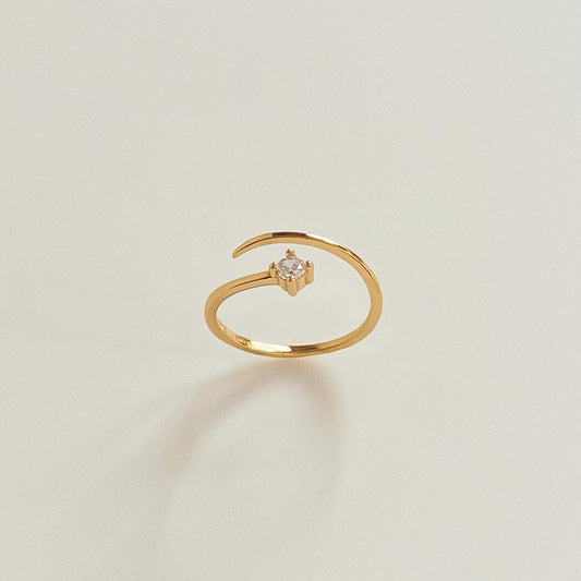 Solo Spark adjustable gold pinky ring standing upright with single cubic zirconia facing forward on light background