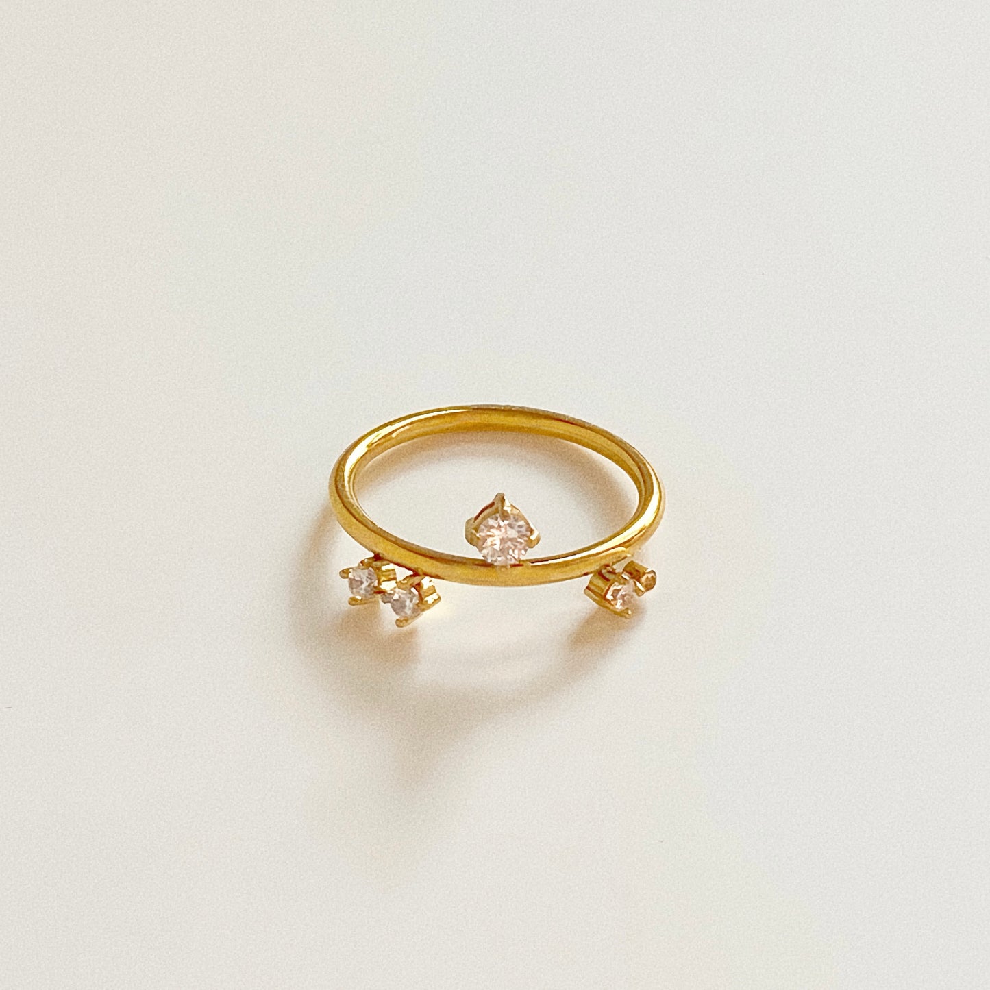 18k gold plated organic shape ring with asymmetric crystal placement, isolated on white.