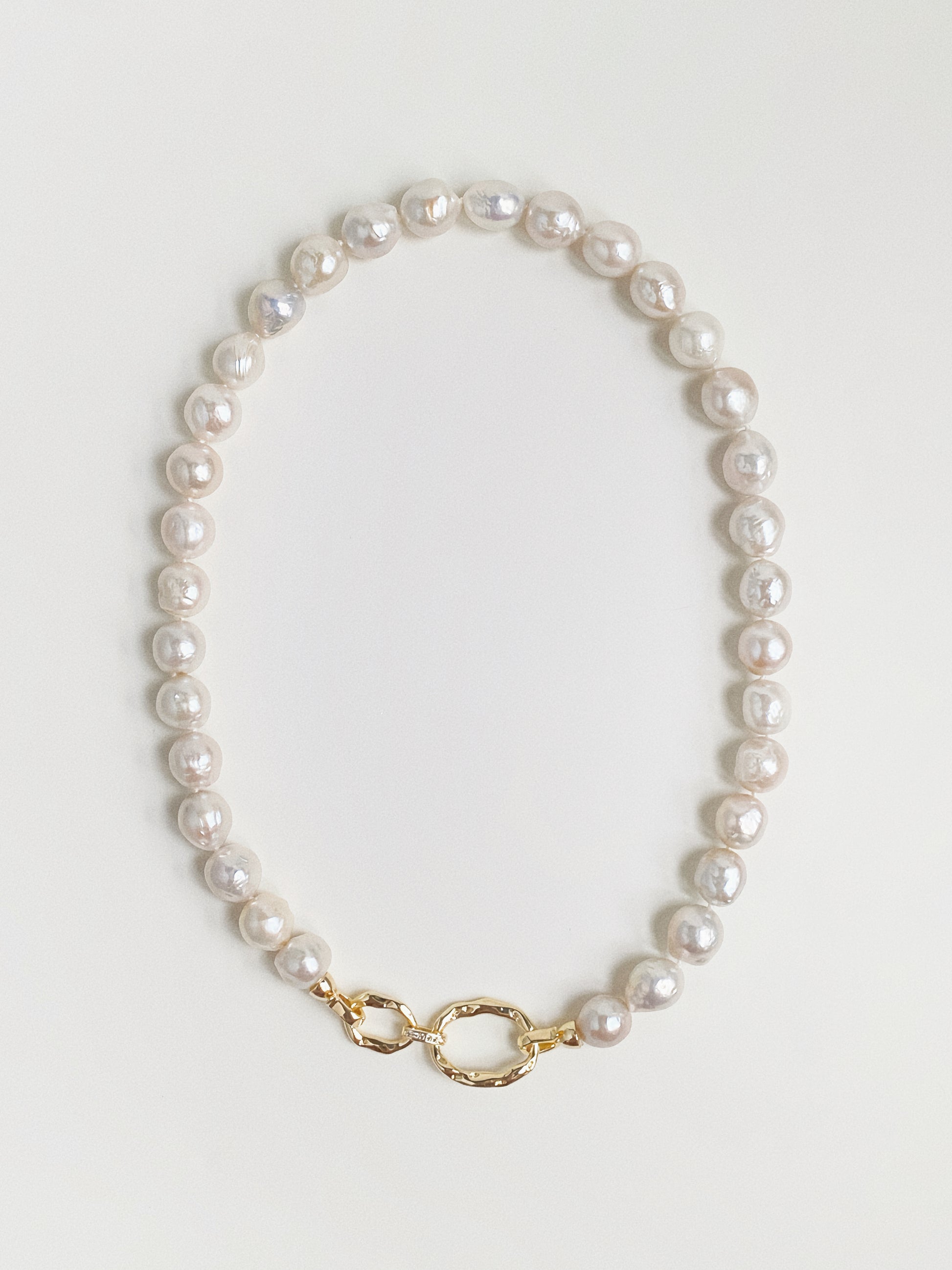 Grand Baroque freshwater pearl necklace with hammered gold double-link front clasp flat lay by Deja Vu Jewellery