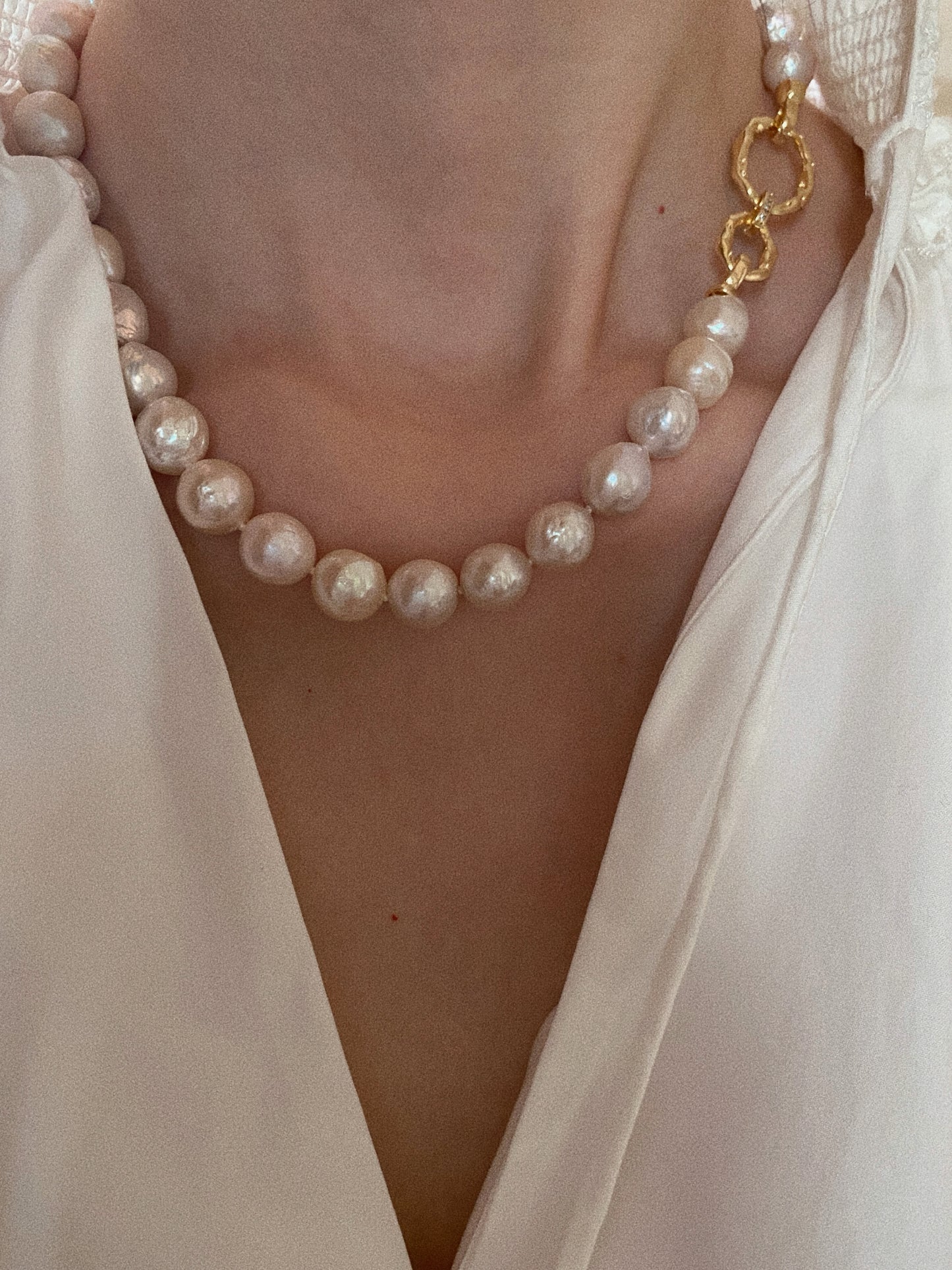Grand Baroque freshwater pearl necklace worn on model with V-neck blouse showing front-facing hammered gold clasp at 45cm princess length
