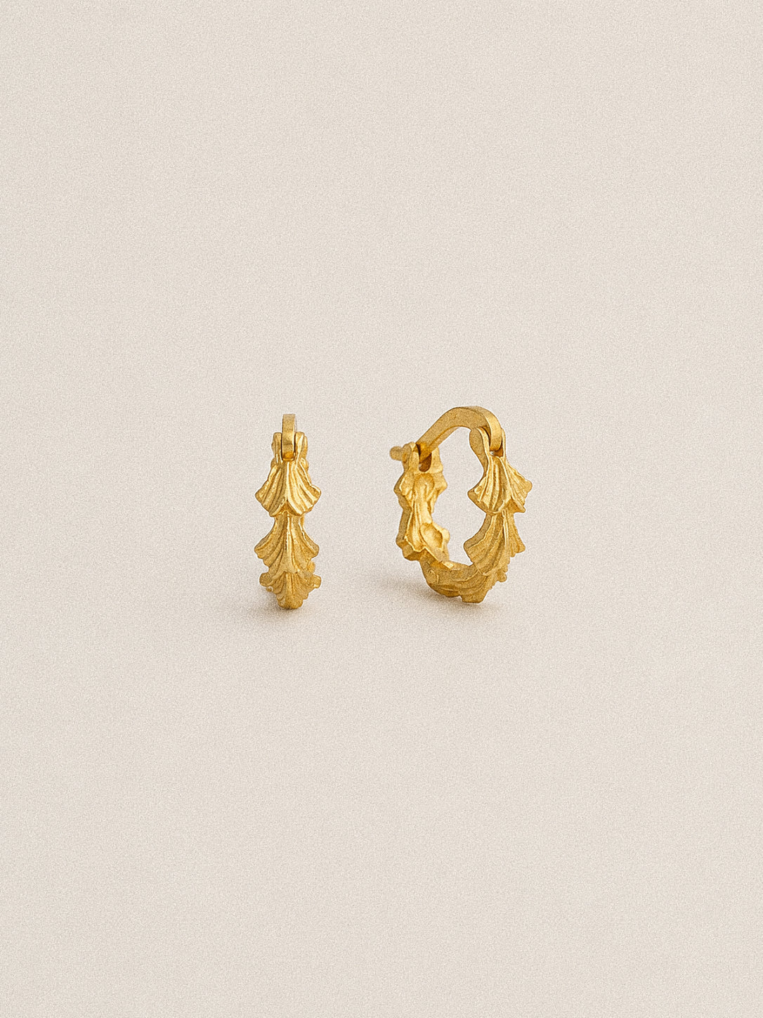 Grove gold leaf hoop earrings in thick gold plating over 925 sterling silver, showing the layered carved leaf design.