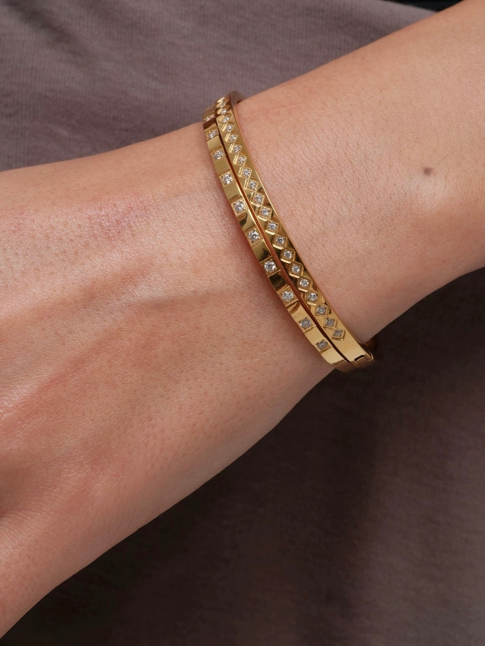Detailed close-up of a gold rhombus and square patterned bracelet showing the high-shine waterproof finish.