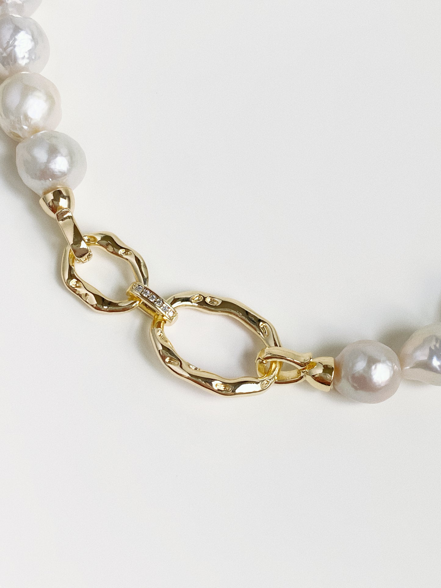 Sculptural hammered gold double-link front clasp with cz detail on Grand Baroque pearl necklace