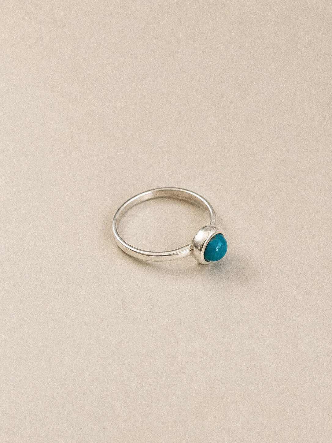 Side view of the handmade bezel-set turquoise ring showing the raised cabochon and polished 925 sterling silver band.