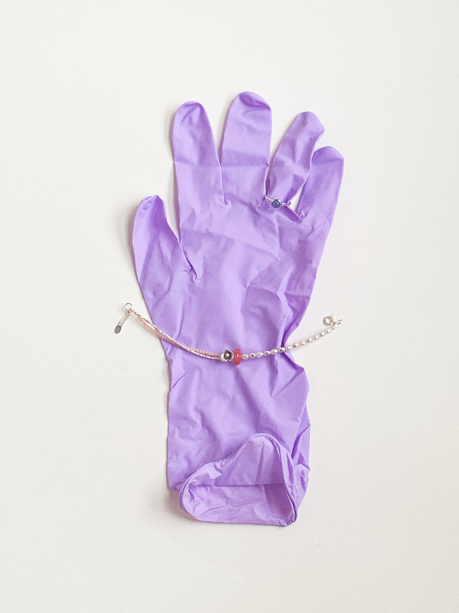 Handheld view of the handcrafted pearl and cherry quartz bracelet, demonstrating the 16cm+2.5cm size scale.