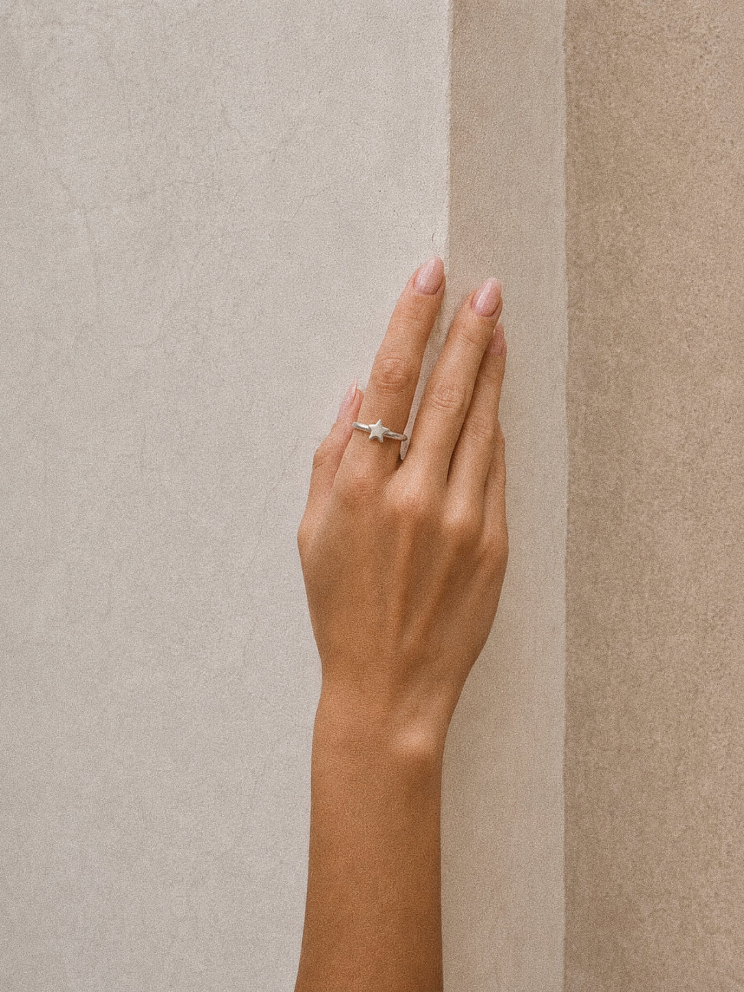 Wish star ring in handmade 925 sterling silver worn on the ring finger, showing its soft brushed finish.