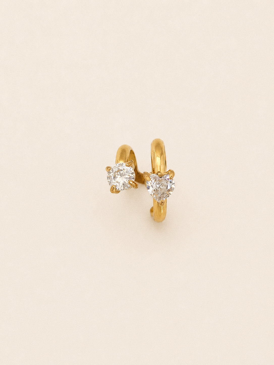 Close up of the Duet spiral ear cuff with a claw set round cz above and a heart cut stone below