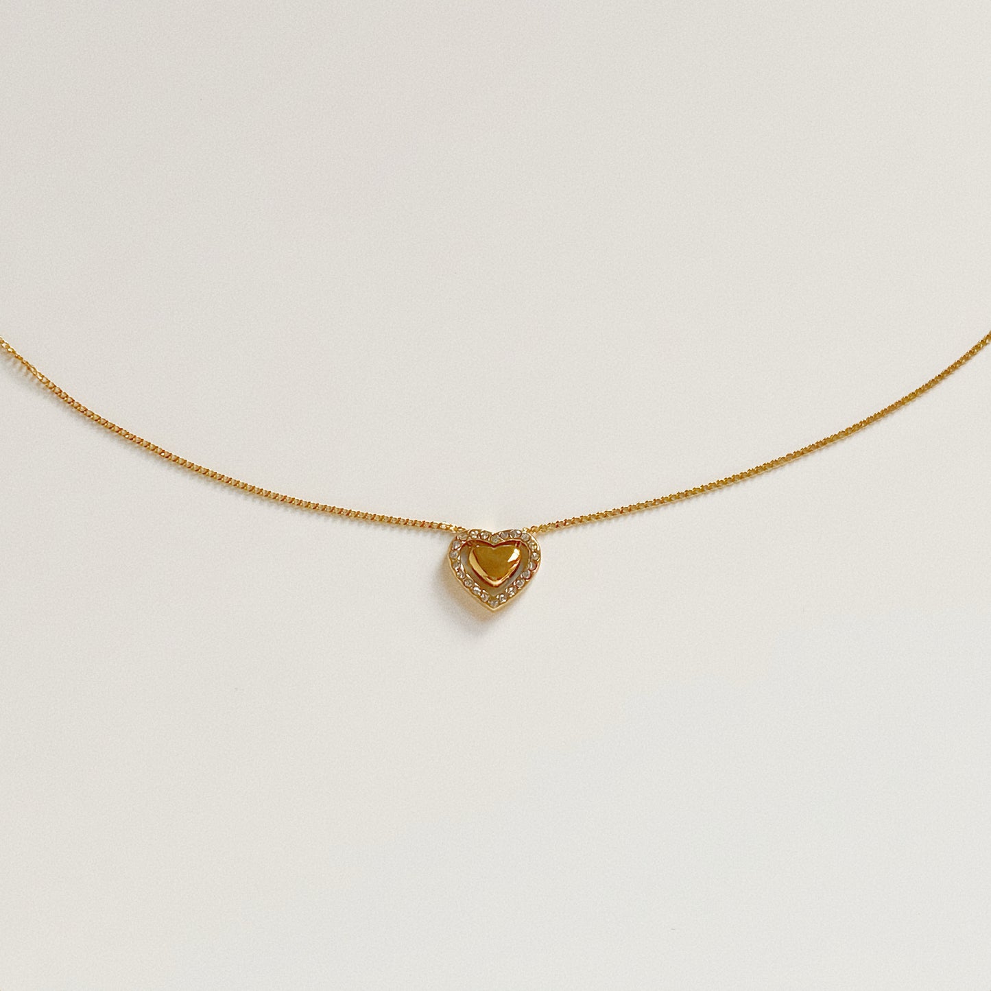 Isolated flat lay of the Fluttering Heart Necklace, a stainless steel waterproof pendant with cubic zirconia details.