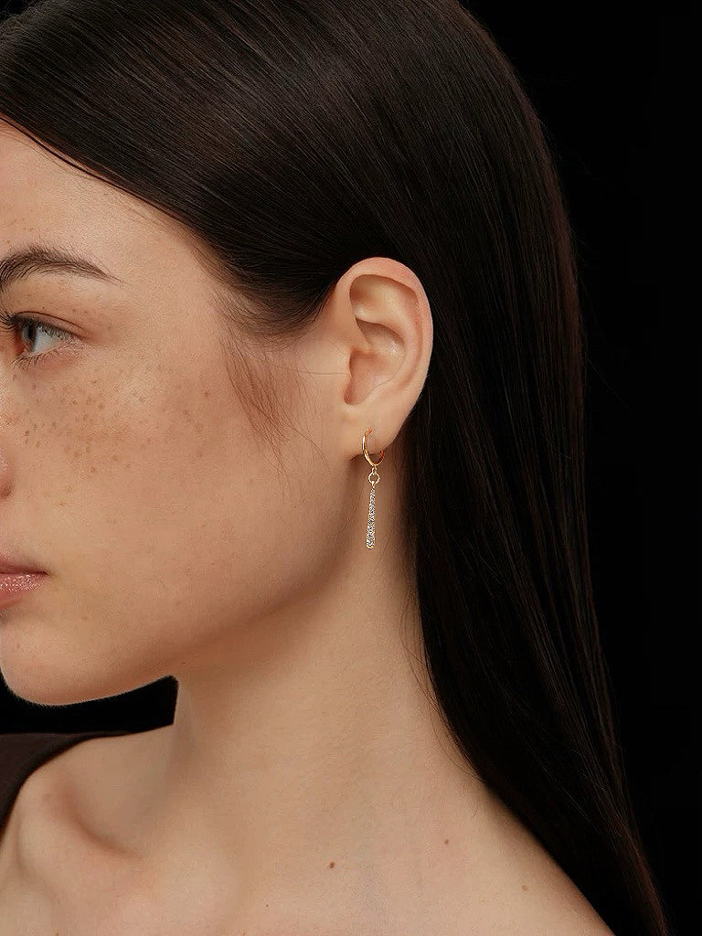 Model wearing gold linear bar drop earrings, showing the 2.3cm length and movement against the neck.