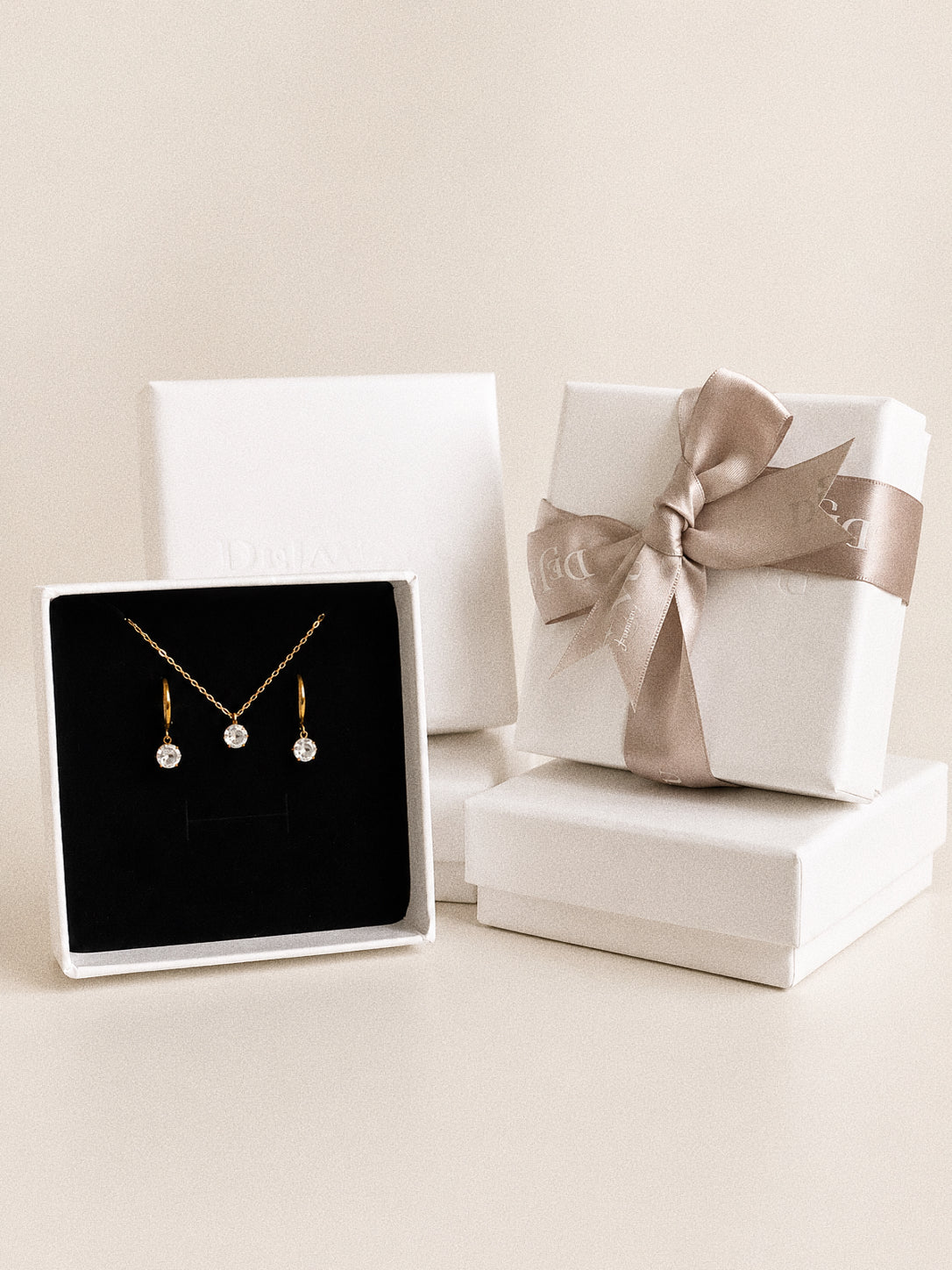 The Icon necklace and huggie earrings presented together in a Deja Vu gift box