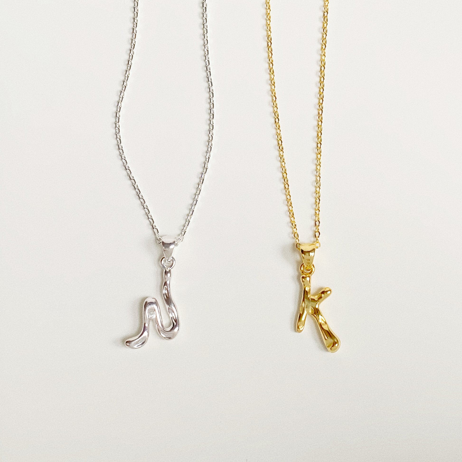 Side by side comparison of Gold Vermeil and Sterling Silver molten initial necklaces.