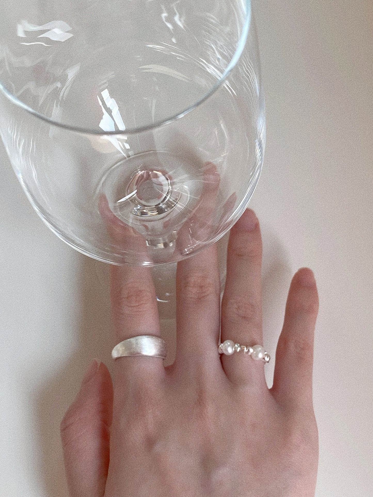 High-angle shot showing the iridescent glow of the natural pearls on the Luna Mist ring, styled on a finger for a minimalist look.