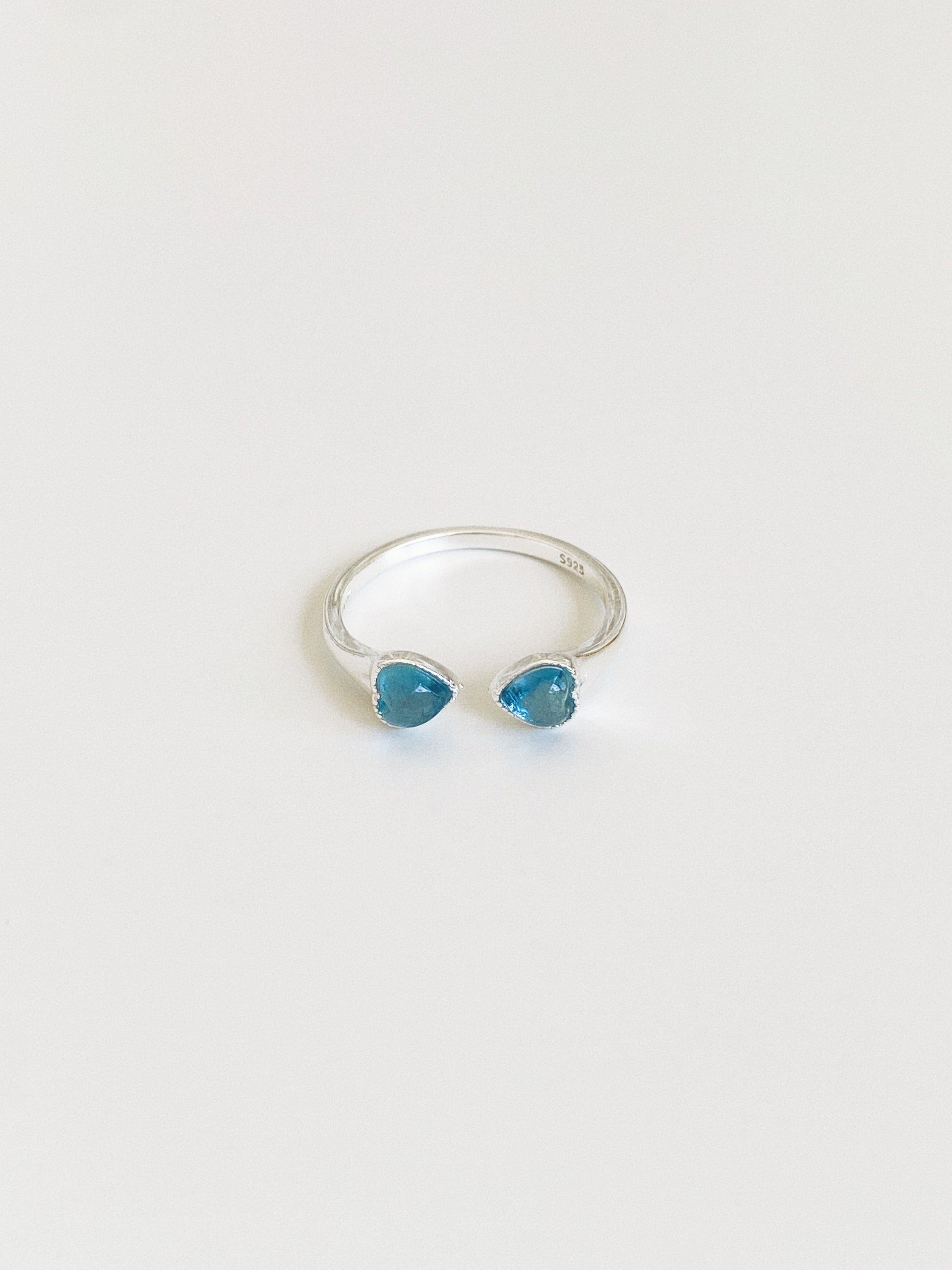 Adjustable open sterling silver ring with two natural aquamarine heart stones facing each other, S925 hallmark visible