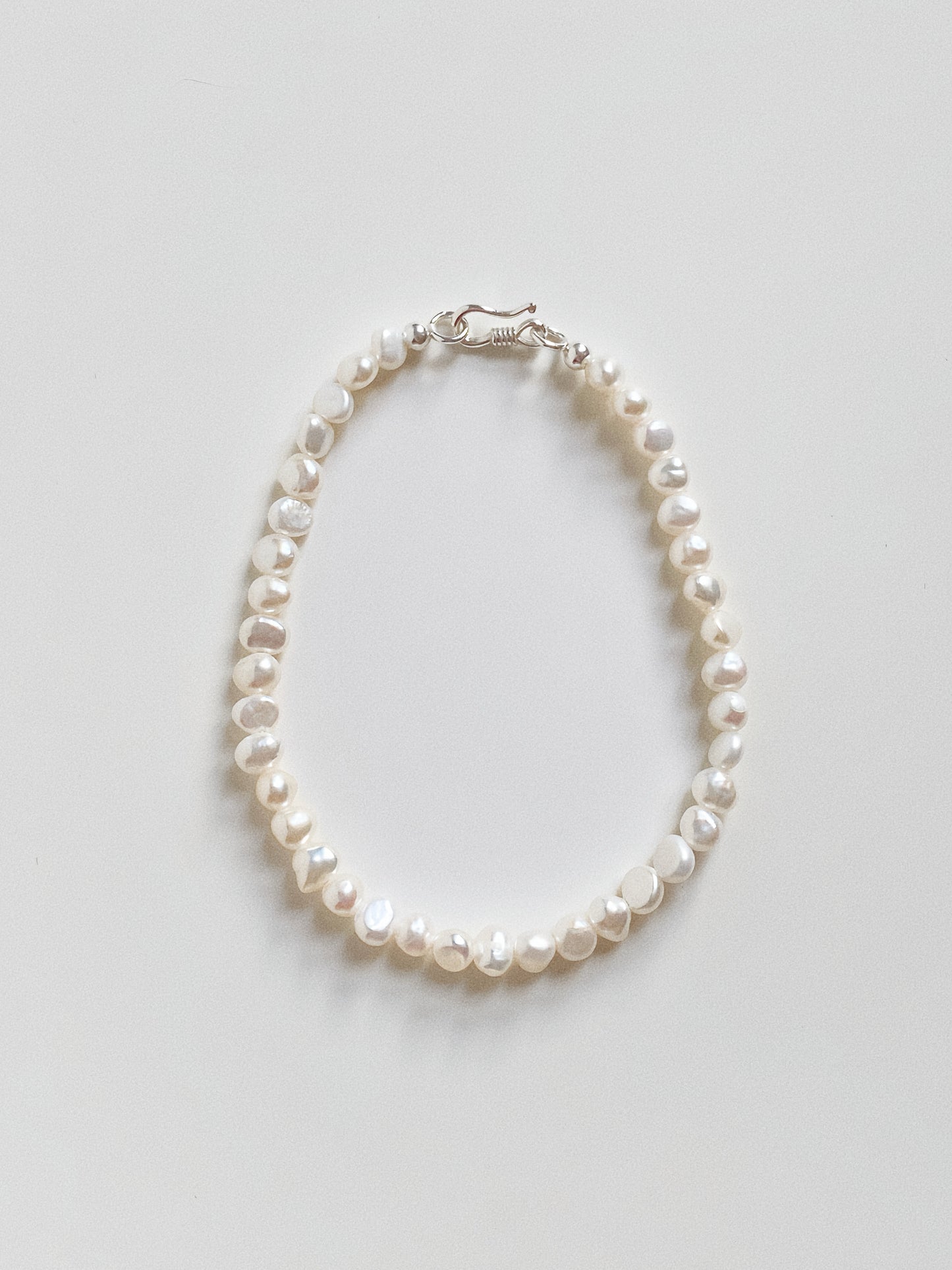 Top down view of the mini baroque pearl bracelet, highlighting the natural irregular shape of the gems.